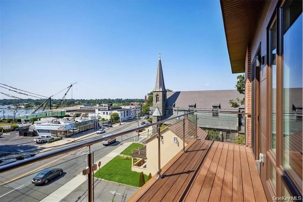 Balcony featuring wood-finish decking and a glass and metal railing system Balcony featuring wood-finish decking and a glass and metal railing system