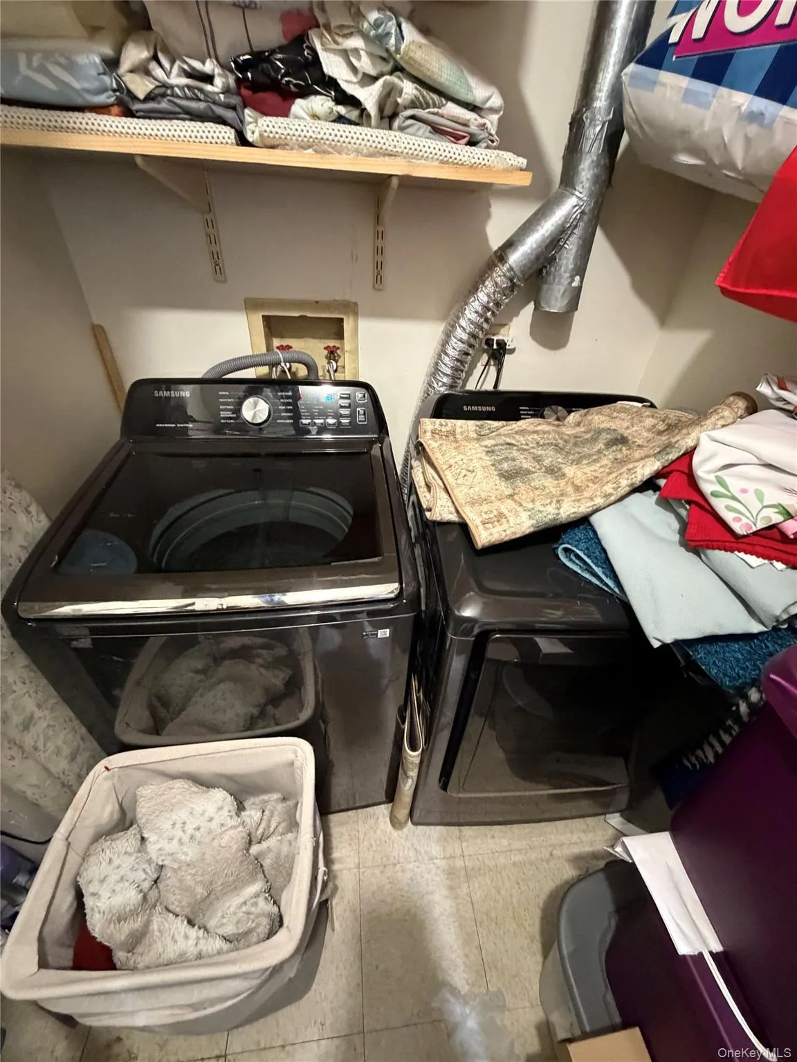 Dedicated laundry area featuring a washer and dryer unit, convenient overhead shelving, and utility hookups Dedicated laundry area featuring a washer and dryer unit, convenient overhead shelving, and utility hookups