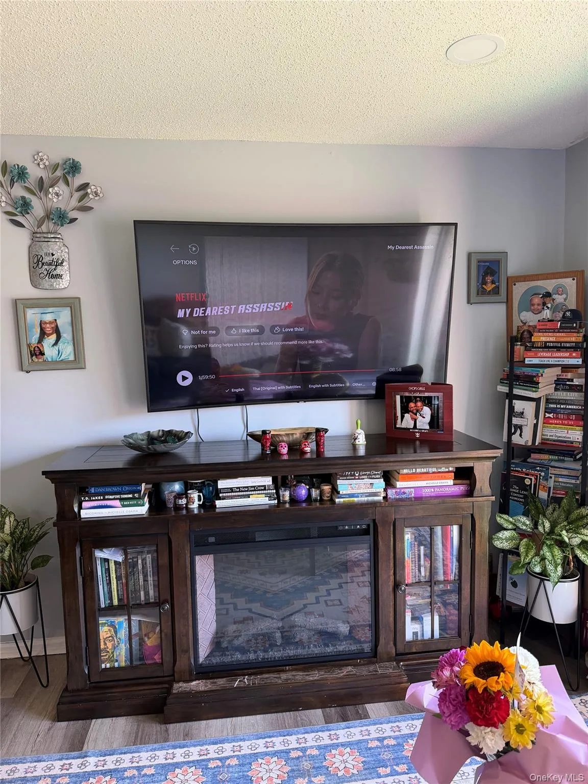 Dark wood-finish media console with an integrated electric fireplace, glass-fronted cabinets, and open shelving Dark wood-finish media console with an integrated electric fireplace, glass-fronted cabinets, and open shelving