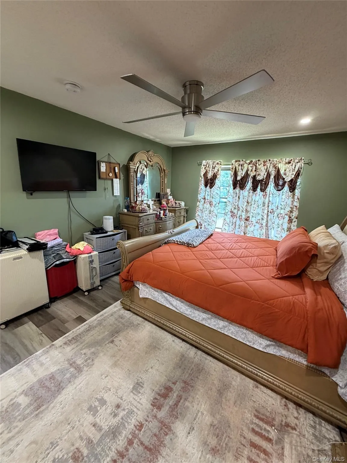 Spacious room featuring wood-finish flooring, a contemporary ceiling fan with integrated lighting, and a window with natural light Spacious room featuring wood-finish flooring, a contemporary ceiling fan with integrated lighting, and a window with natural light