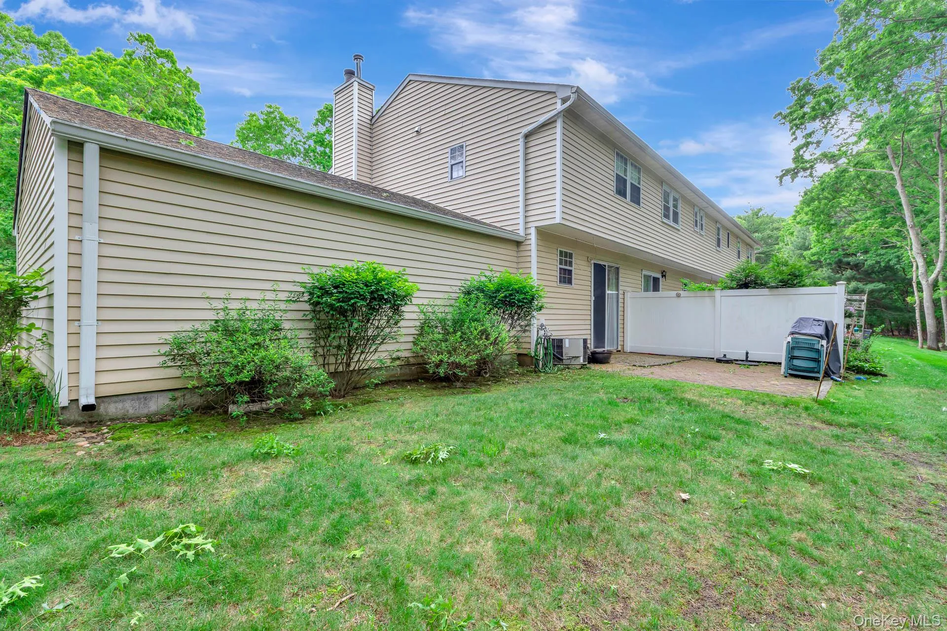 Rear exterior featuring horizontal siding, a patio area, and a white privacy fence Rear exterior featuring horizontal siding, a patio area, and a white privacy fence
