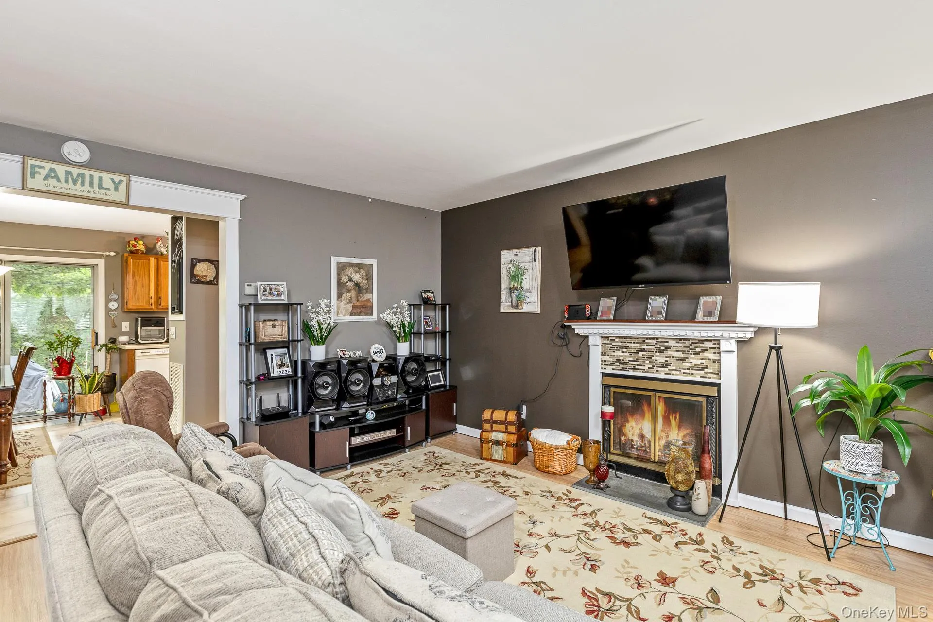 Living area featuring a fireplace with a decorative tile surround and white mantel Living area featuring a fireplace with a decorative tile surround and white mantel