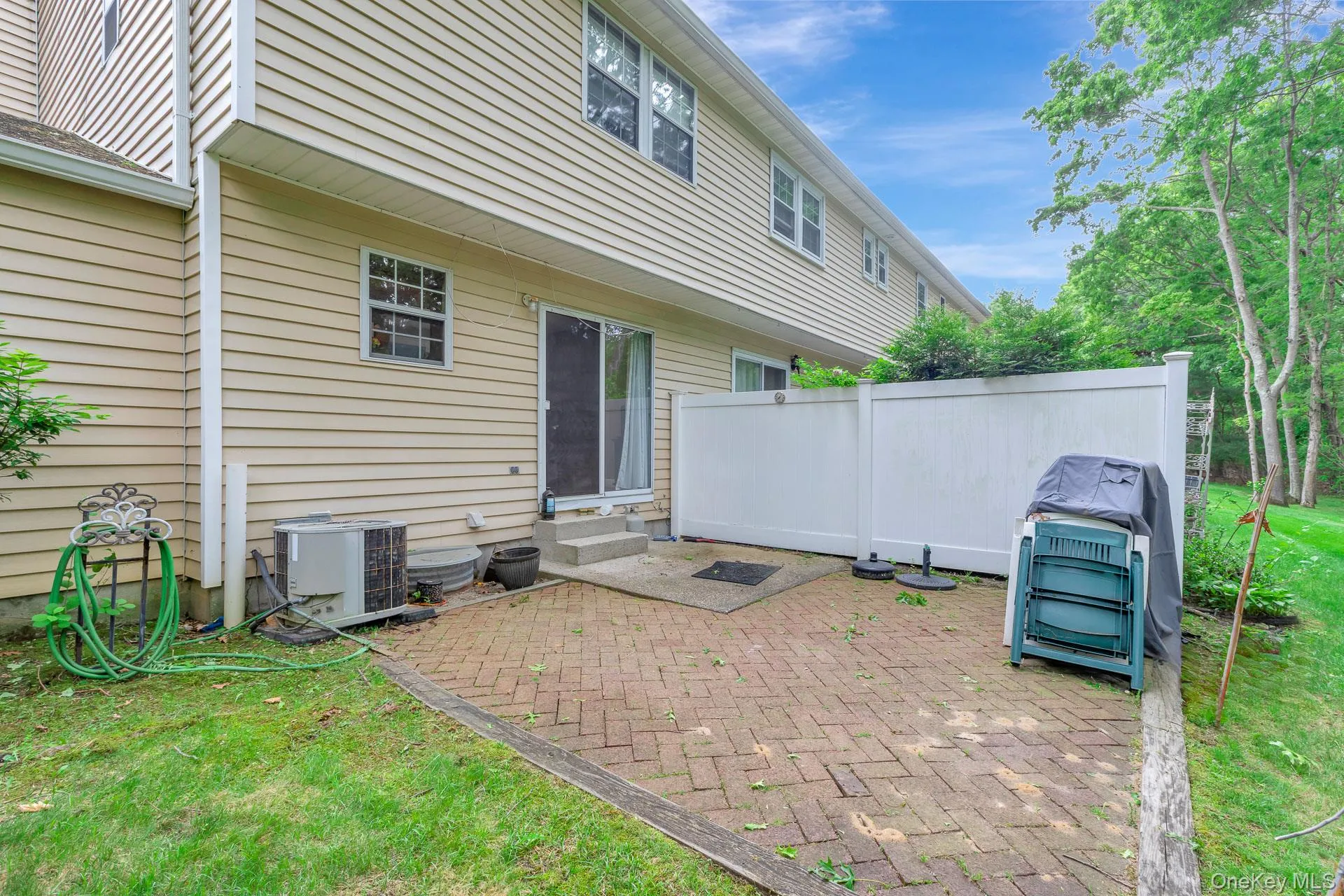 Brick paver patio area featuring a privacy fence and direct access to the interior via a sliding glass door Brick paver patio area featuring a privacy fence and direct access to the interior via a sliding glass door