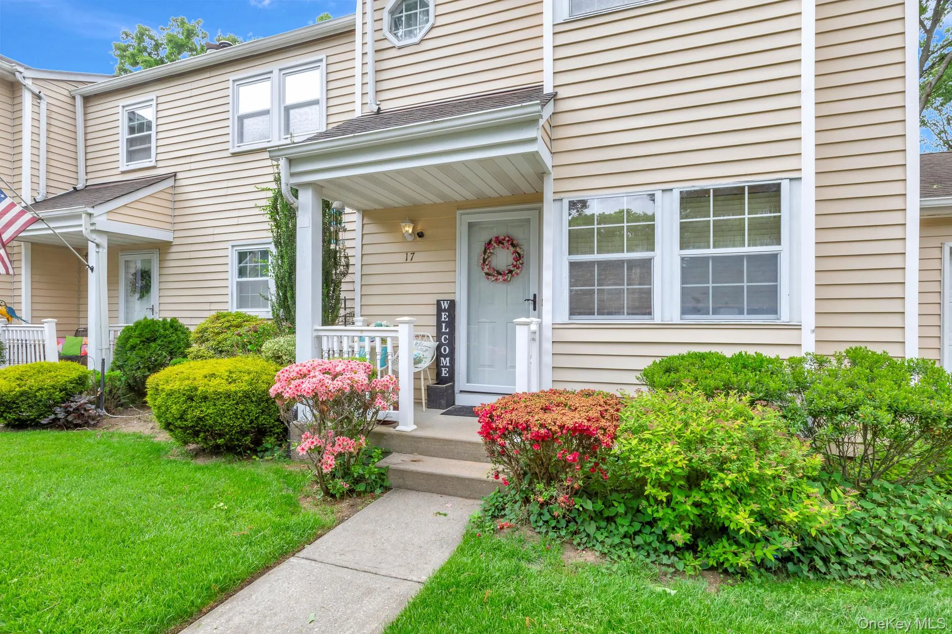 Entryway with covered porch, white railing, and concrete steps Entryway with covered porch, white railing, and concrete steps