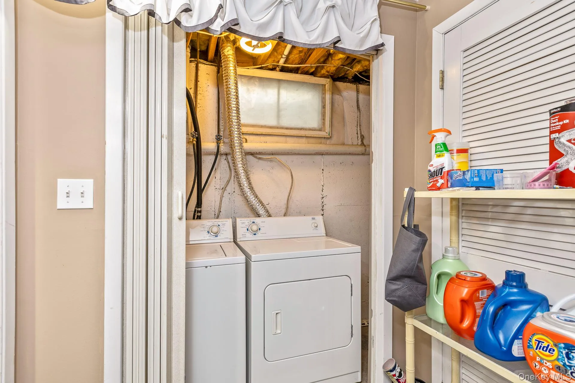 Dedicated laundry area featuring a washer and dryer, exposed ceiling joists, and a utility window Dedicated laundry area featuring a washer and dryer, exposed ceiling joists, and a utility window