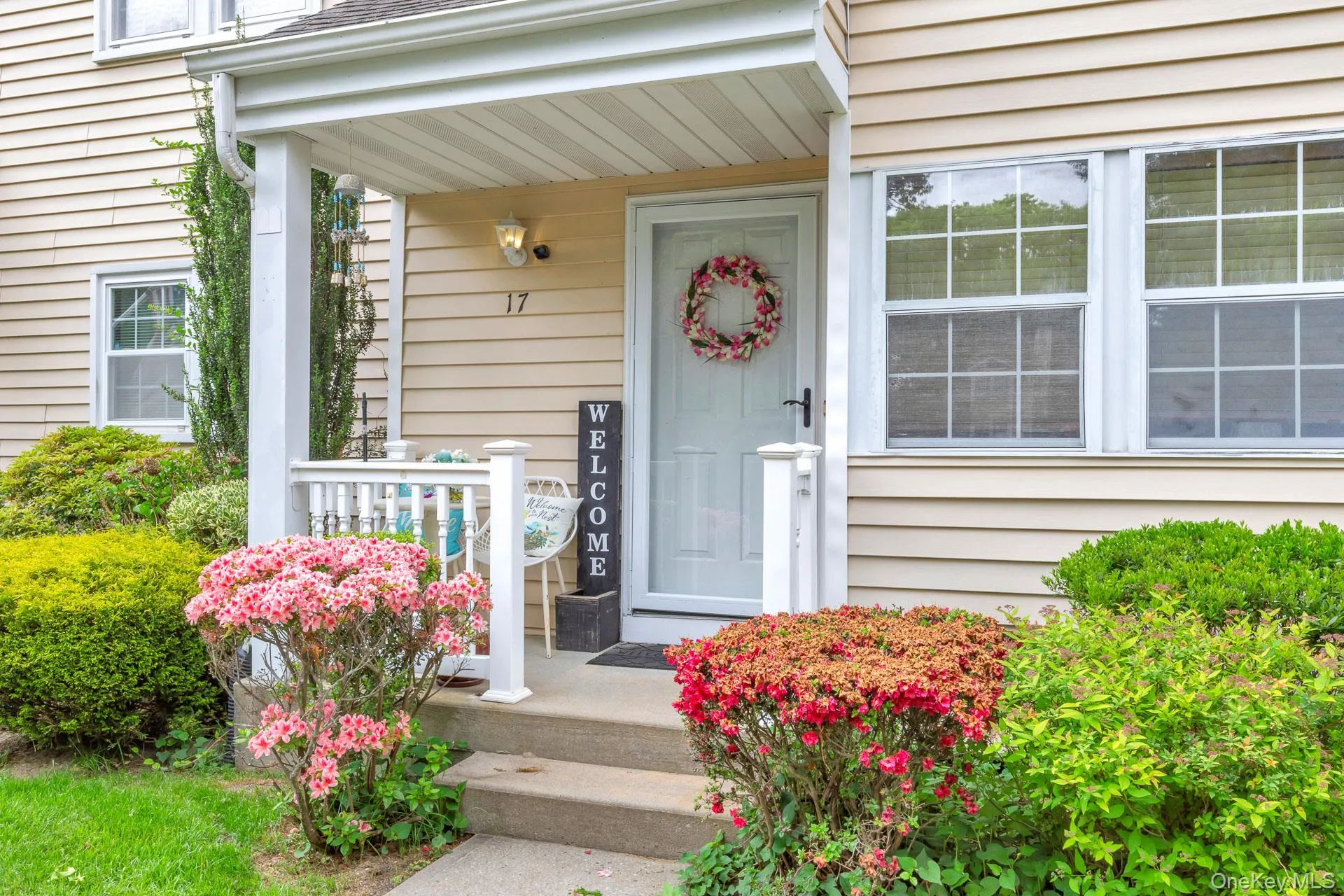 Inviting front porch with a white railing and concrete steps Inviting front porch with a white railing and concrete steps