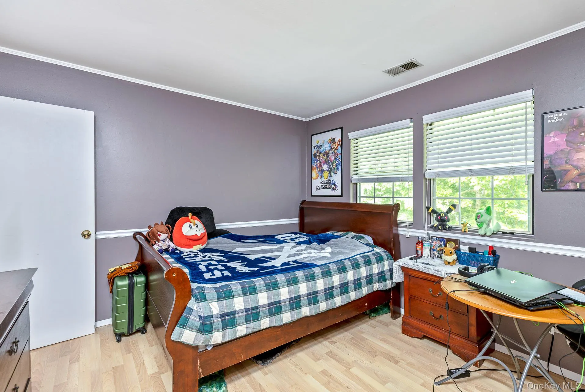 Room featuring light wood-finish flooring, white trim, and two windows with white blinds Room featuring light wood-finish flooring, white trim, and two windows with white blinds