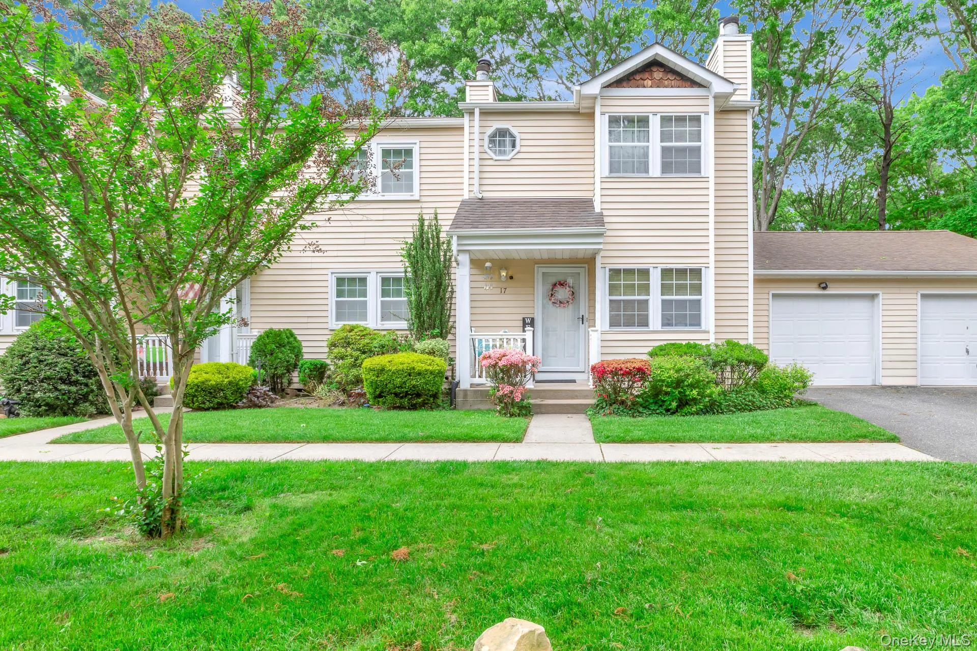 Cream-colored vinyl siding exterior with white trim windows and a front entry porch Cream-colored vinyl siding exterior with white trim windows and a front entry porch