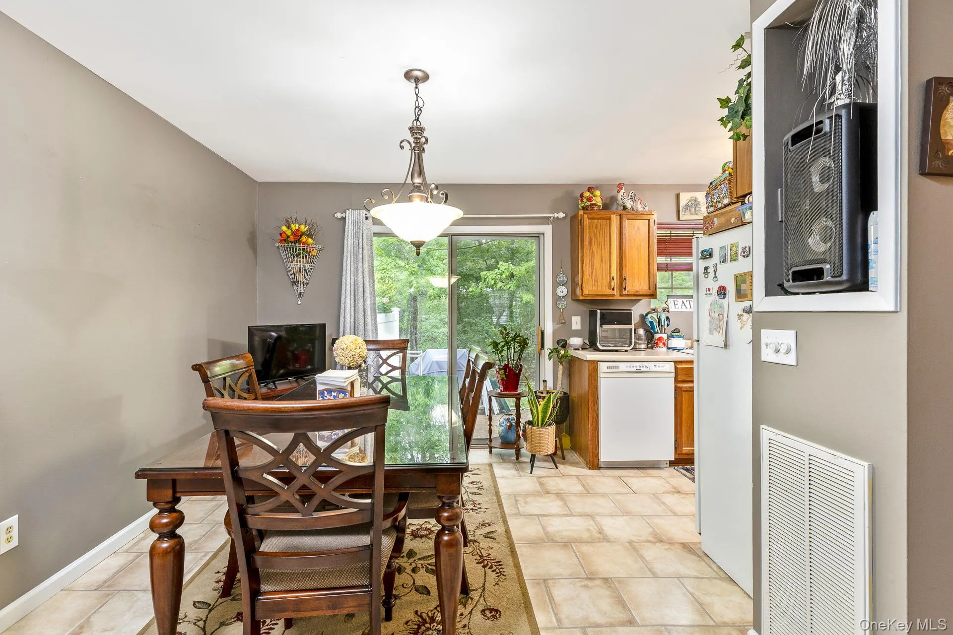 Dining area featuring neutral wall paint, a traditional chandelier, and tile flooring extending into the kitchen Dining area featuring neutral wall paint, a traditional chandelier, and tile flooring extending into the kitchen