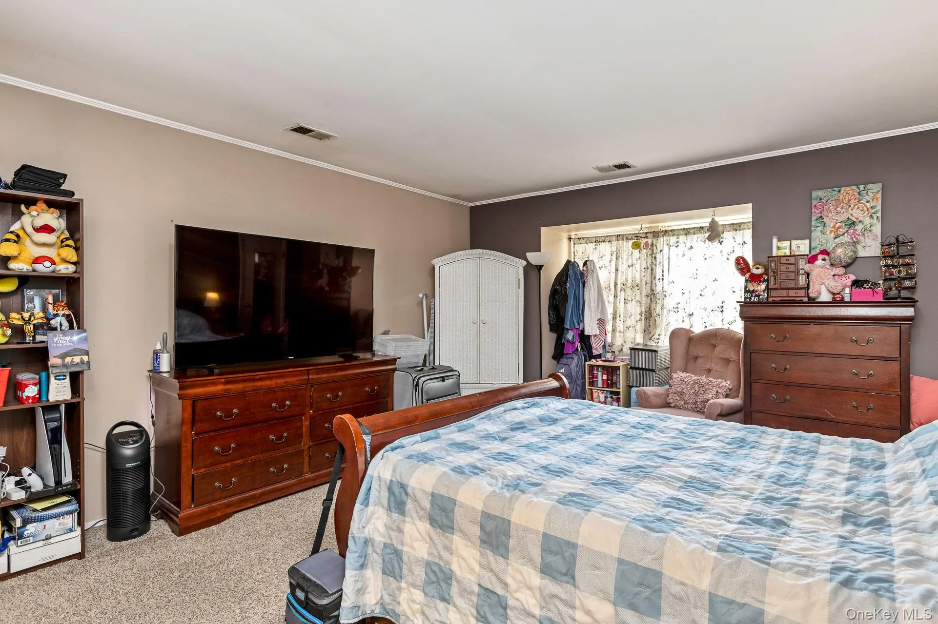 Carpeted room featuring a window with natural light, a white built-in wardrobe, and a contrasting accent wall Carpeted room featuring a window with natural light, a white built-in wardrobe, and a contrasting accent wall