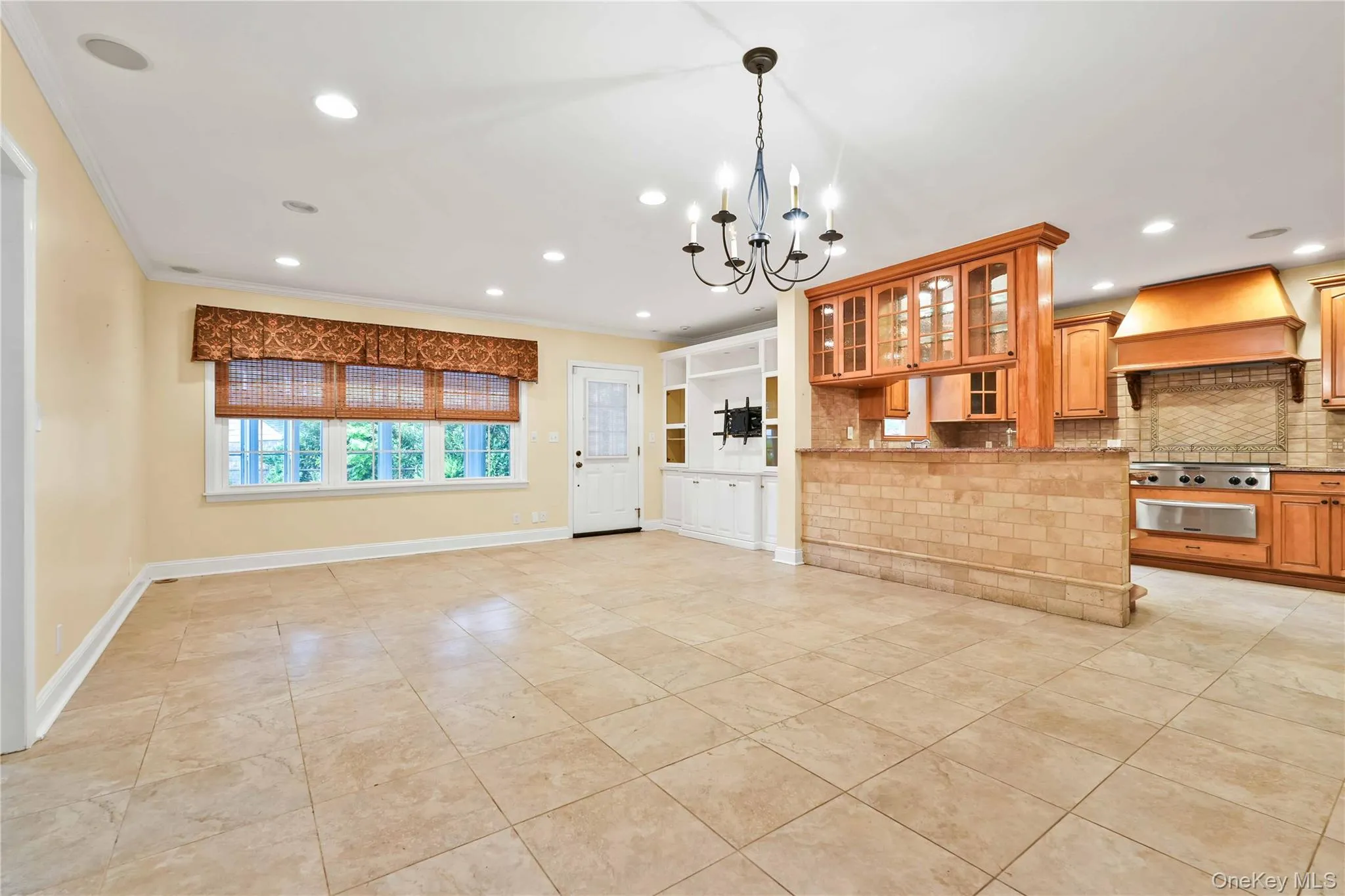 Spacious living area featuring large Porcelain tile flooring, recessed lighting, and a prominent chandelier Spacious living area featuring large Porcelain tile flooring, recessed lighting, and a prominent chandelier