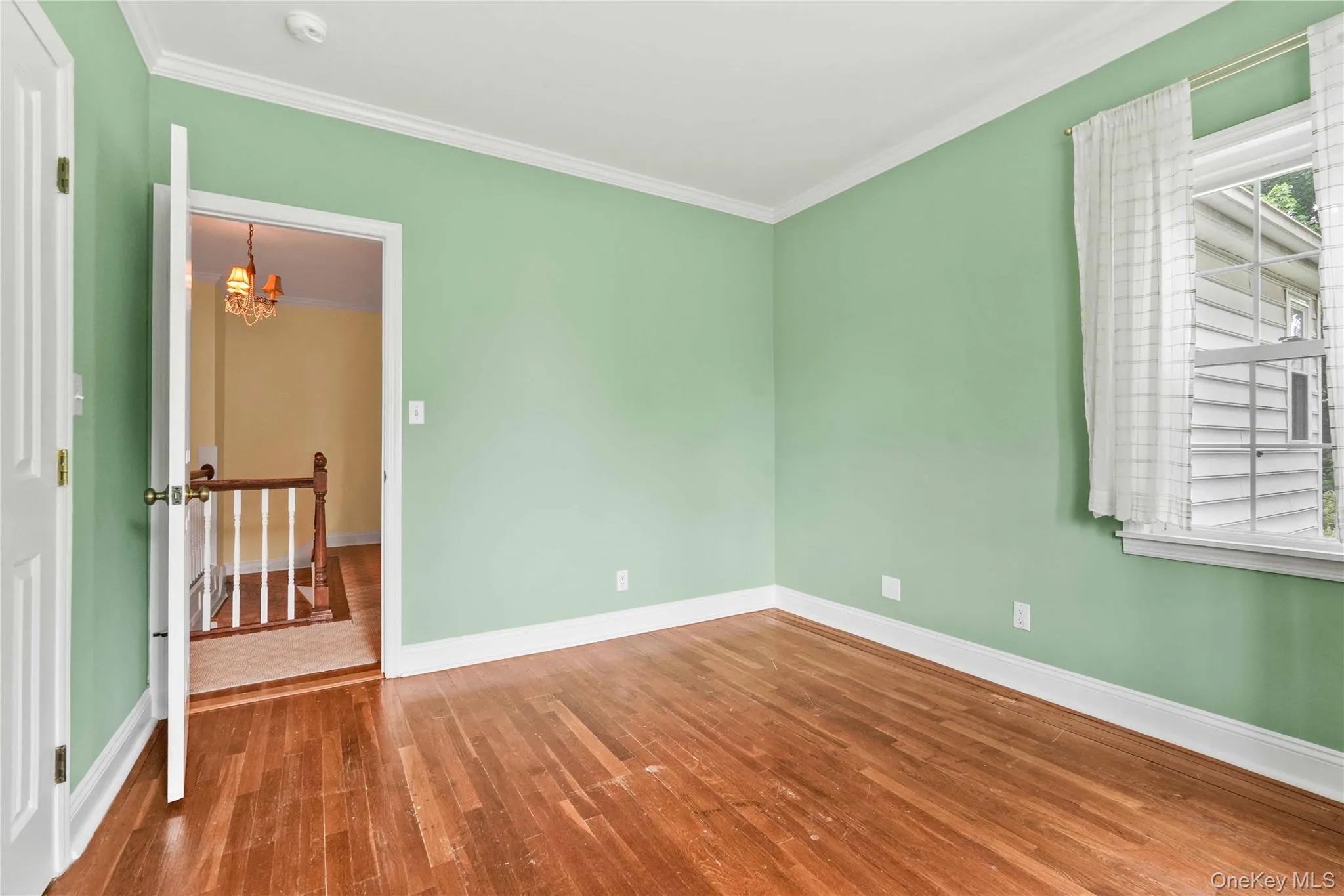 Bedroom 1Hardwood flooring complements light green walls and white trim Bedroom 1Hardwood flooring complements light green walls and white trim