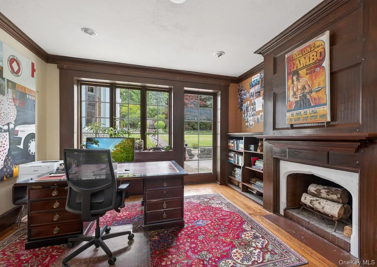 Wood-paneled library with wood-burning fireplace and door to terrace Wood-paneled library with wood-burning fireplace and door to terrace
