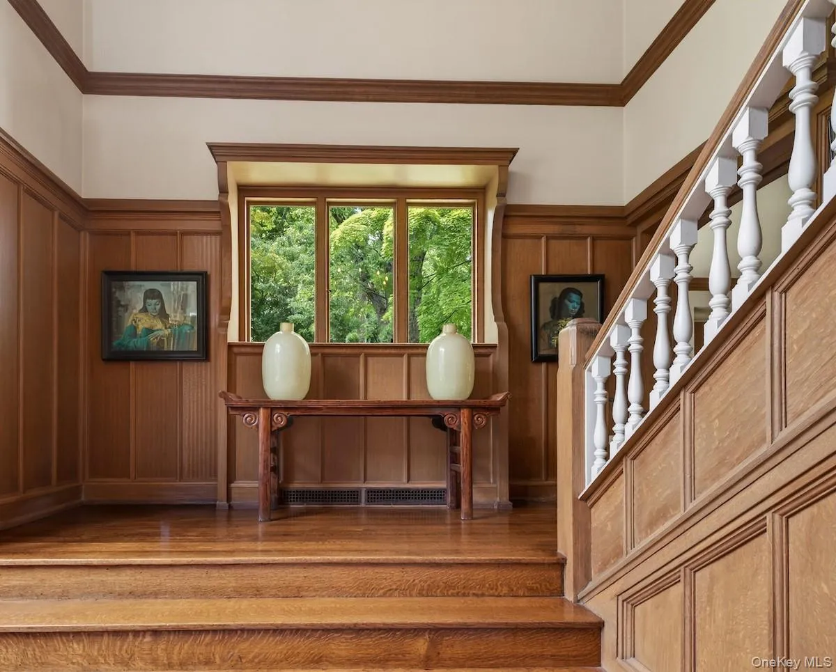 Original wood paneling in stair hall leading to living room and second level Original wood paneling in stair hall leading to living room and second level