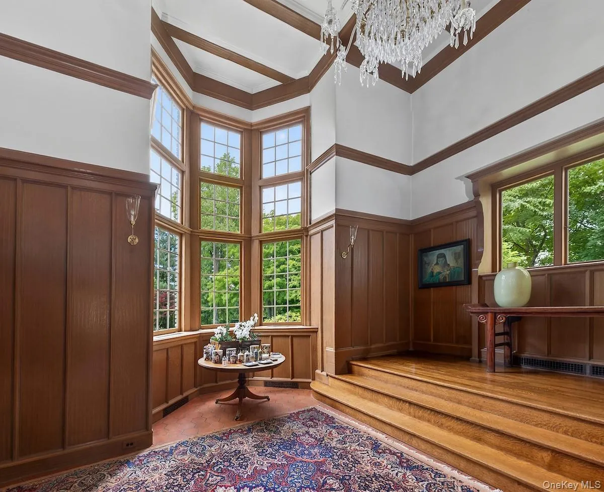 Towering stair hall with original wood-paneled walls and decorative ceiling beams Towering stair hall with original wood-paneled walls and decorative ceiling beams