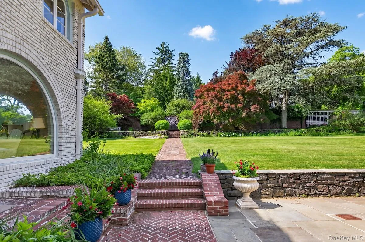 Enter the rear terrace and sweeping back lawn and gardens from sun room Enter the rear terrace and sweeping back lawn and gardens from sun room