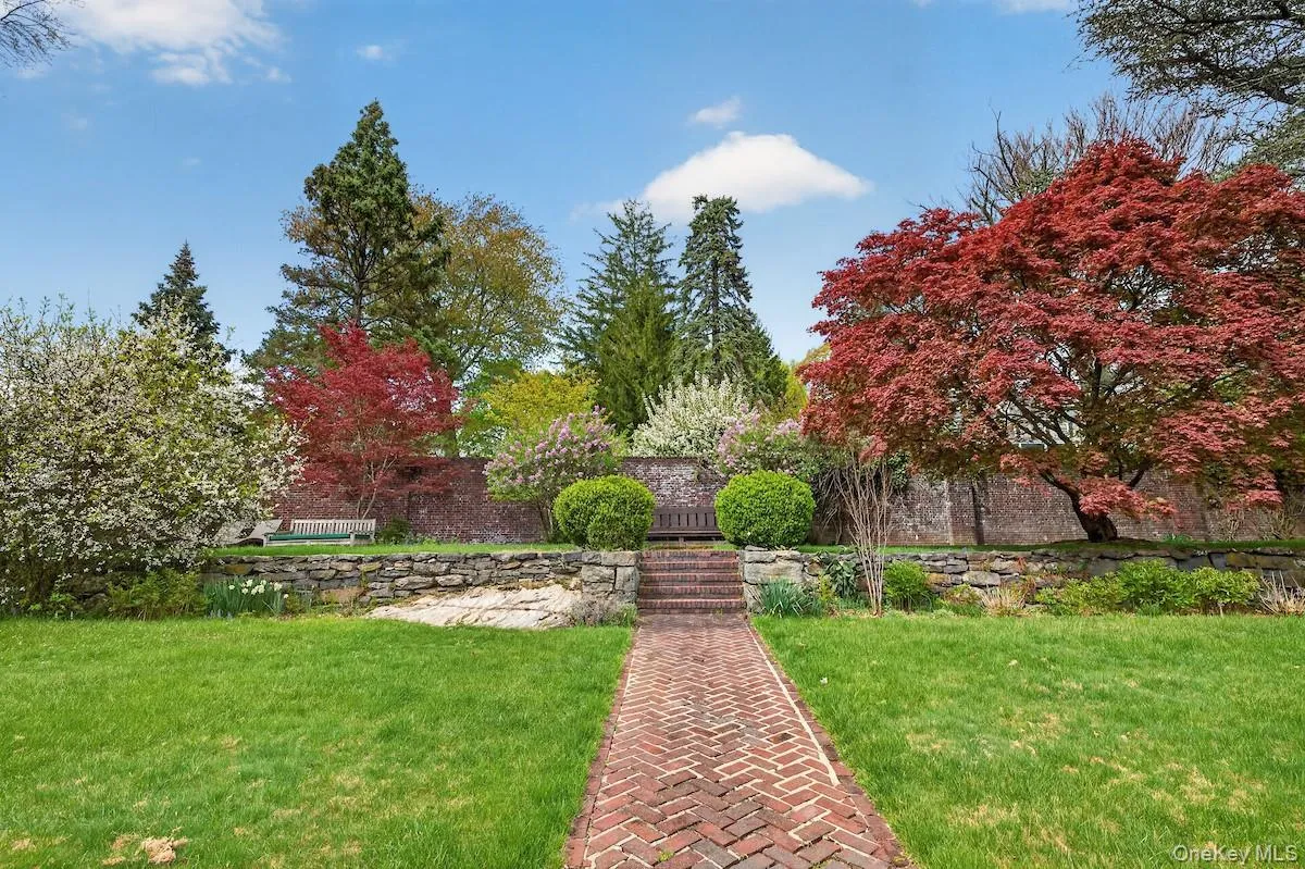 Rear view of grounds with backdrop of flowering and towering trees Rear view of grounds with backdrop of flowering and towering trees