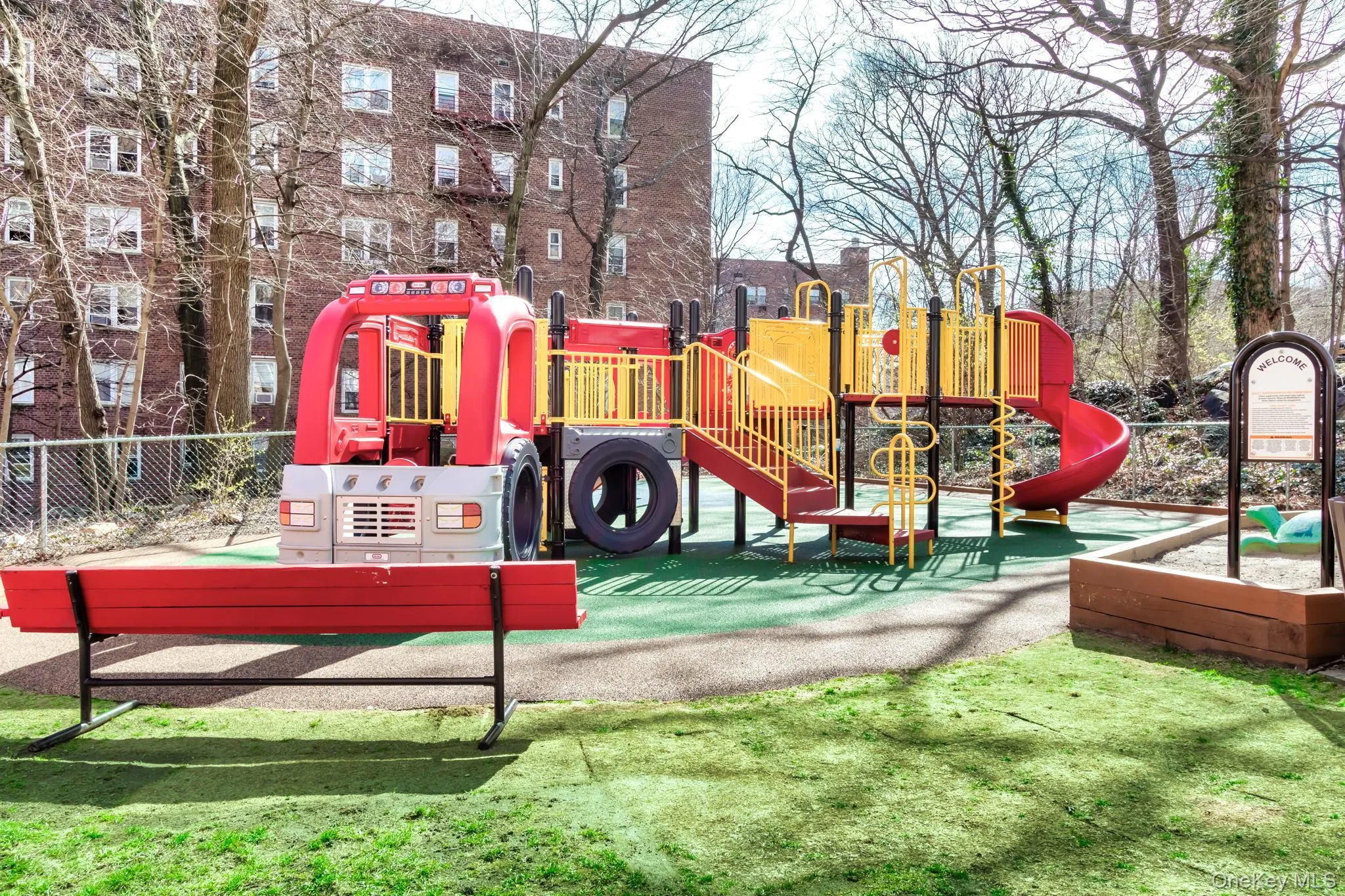 Outdoor playground featuring a red and yellow play structure with slides and climbing elements Outdoor playground featuring a red and yellow play structure with slides and climbing elements