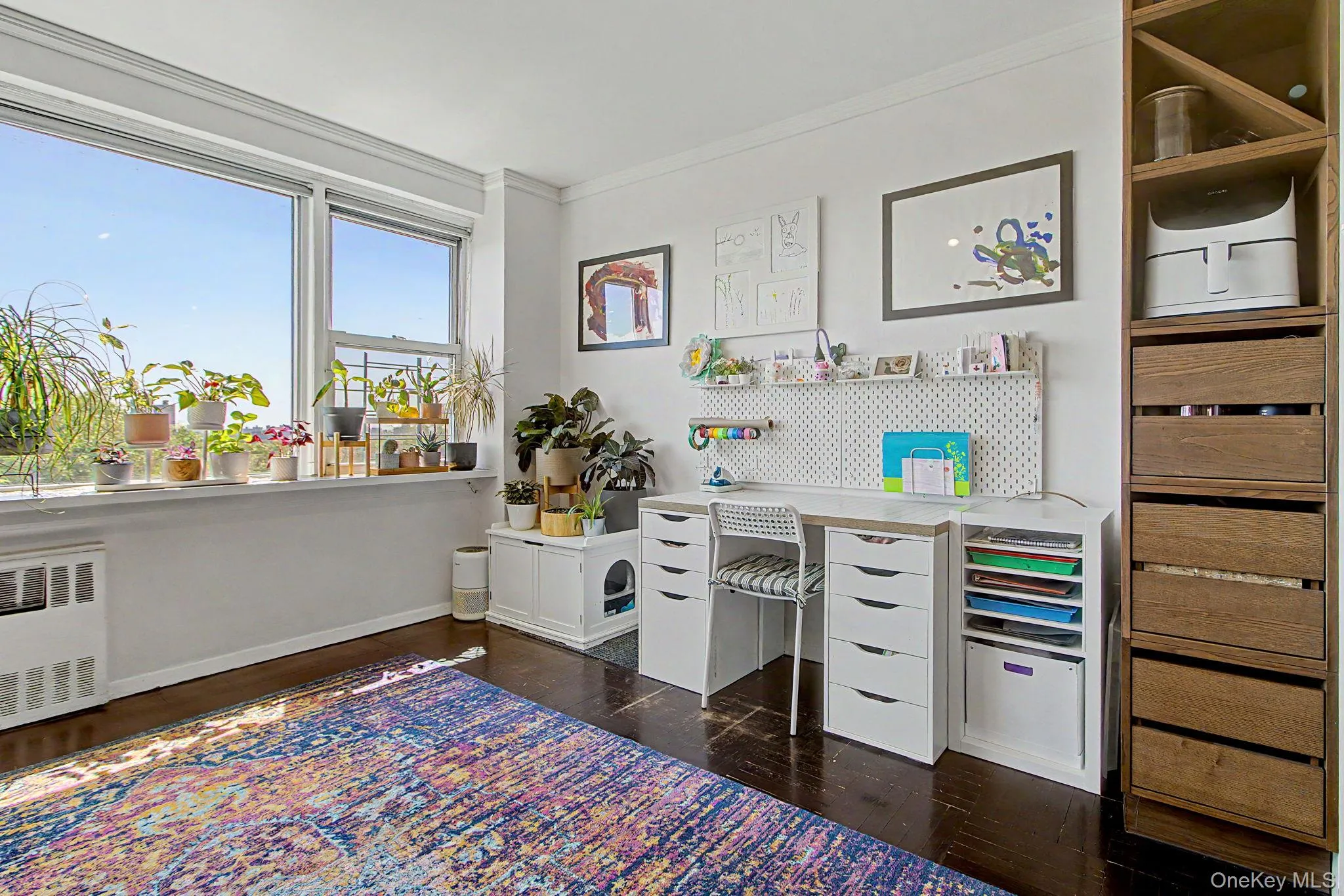 Expansive window with a wide sill, complemented by dark wood-finish flooring Expansive window with a wide sill, complemented by dark wood-finish flooring