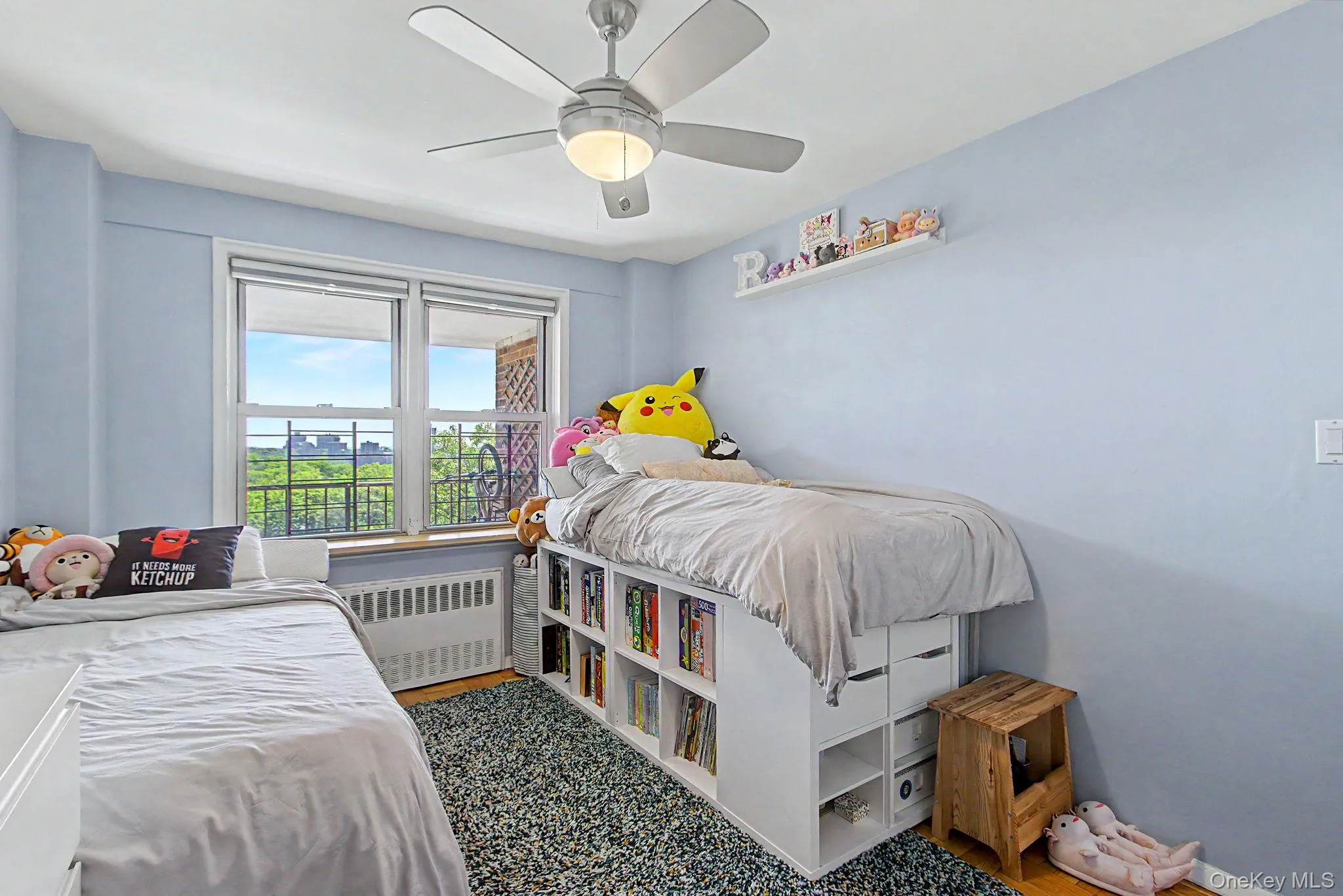 Bright room with a large window, a ceiling fan with integrated lighting, and a built-in shelving unit Bright room with a large window, a ceiling fan with integrated lighting, and a built-in shelving unit