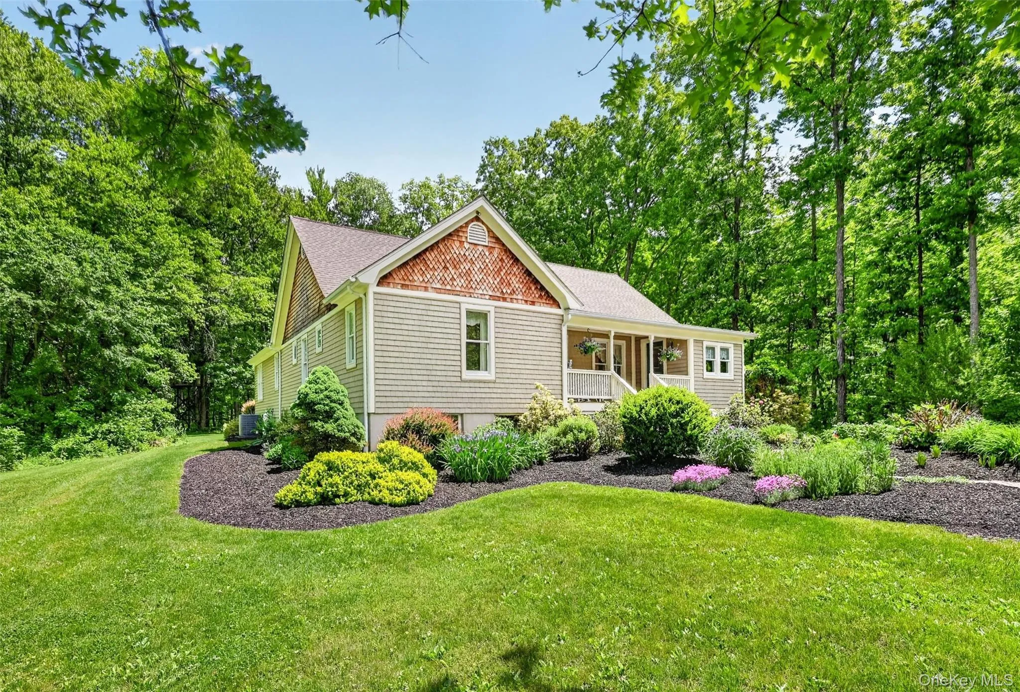 Exterior featuring a covered porch, shake siding, and a gabled roofline Exterior featuring a covered porch, shake siding, and a gabled roofline