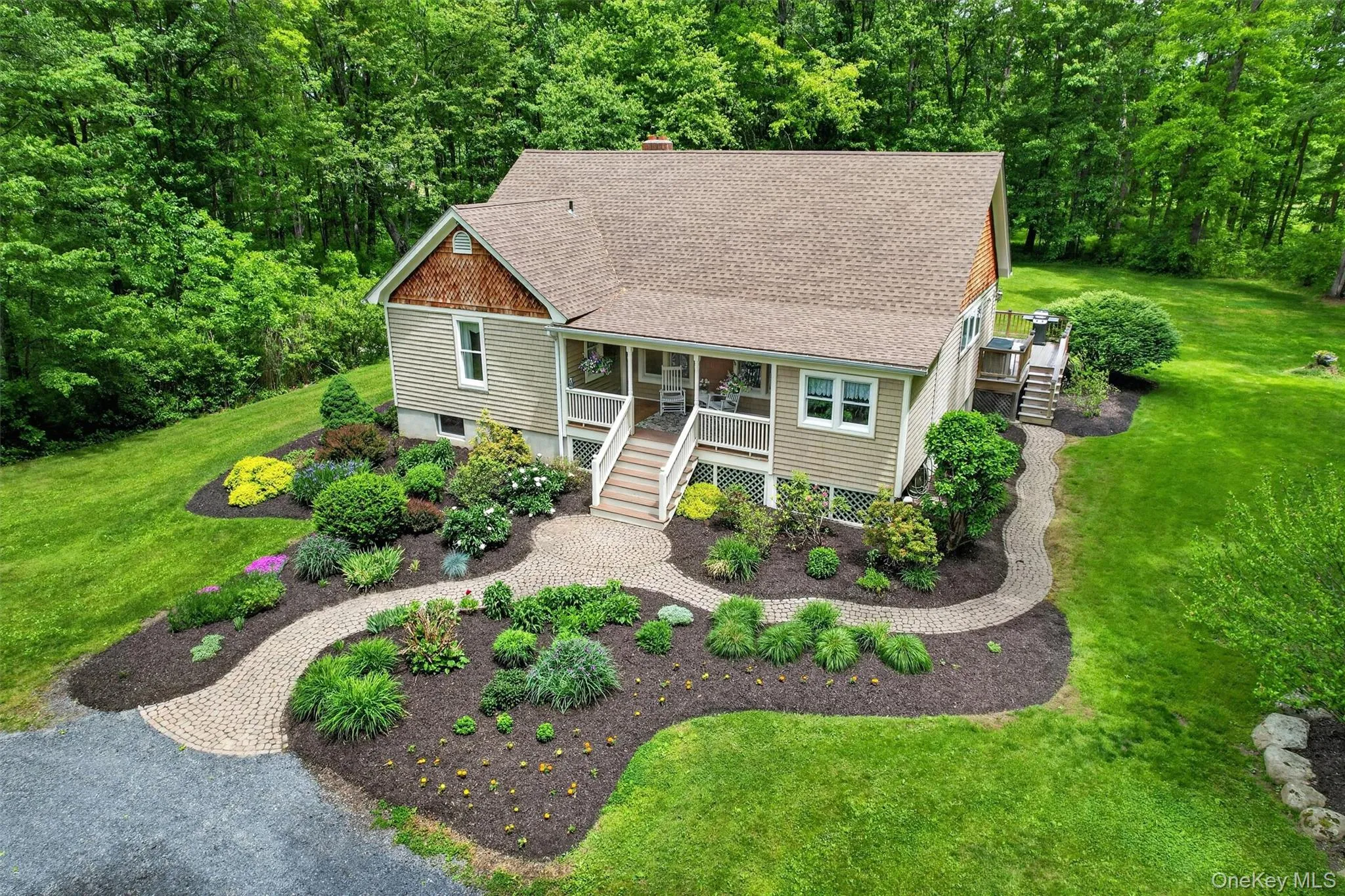 Exterior featuring light-colored siding, a brown shingle roof, and a covered porch with white railings Exterior featuring light-colored siding, a brown shingle roof, and a covered porch with white railings