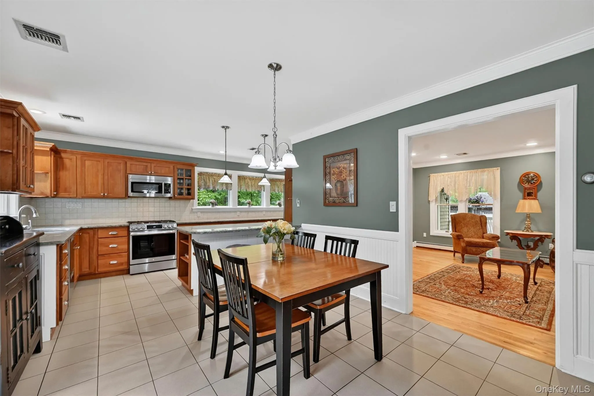 Spacious kitchen with wood cabinetry, stainless steel appliances, and tile flooring Spacious kitchen with wood cabinetry, stainless steel appliances, and tile flooring