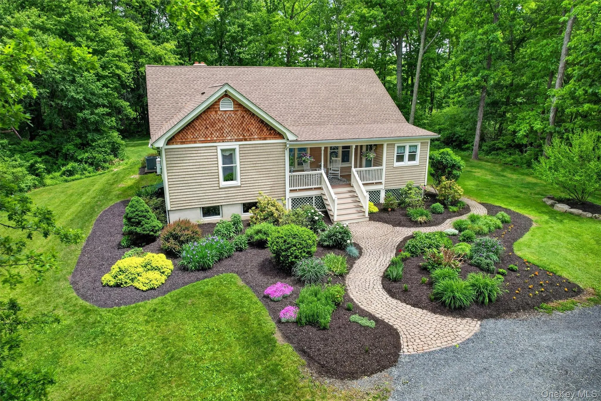 Gable-front home featuring tan horizontal siding and a porch with white railings and steps Gable-front home featuring tan horizontal siding and a porch with white railings and steps