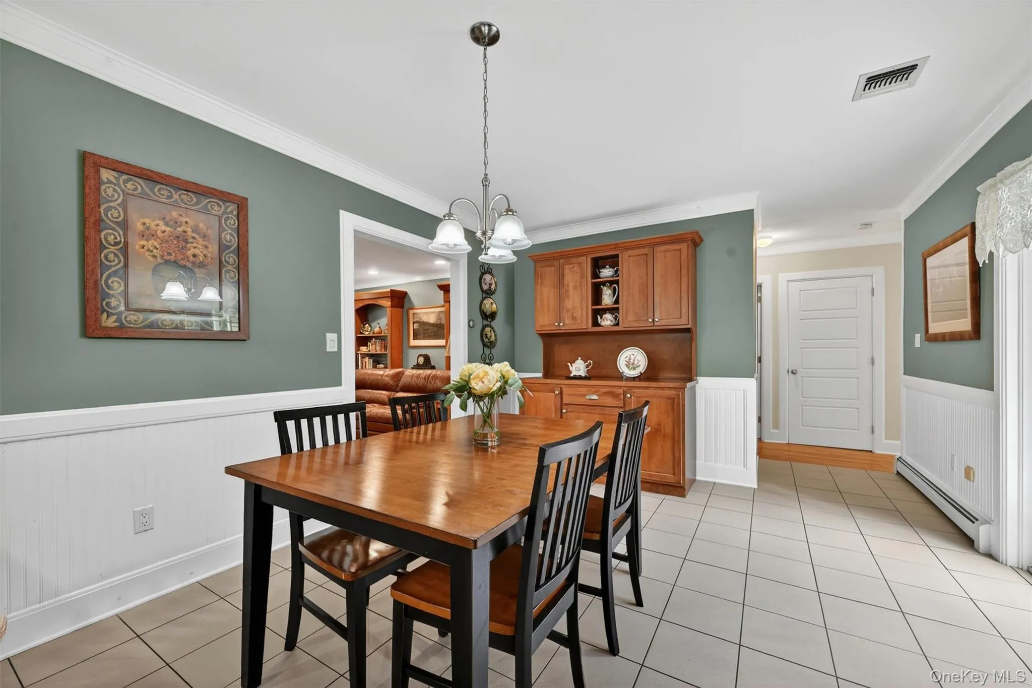 Tiled flooring with contrasting grout, white wainscoting, and a built-in wood-finish cabinet with upper glass-front display Tiled flooring with contrasting grout, white wainscoting, and a built-in wood-finish cabinet with upper glass-front display