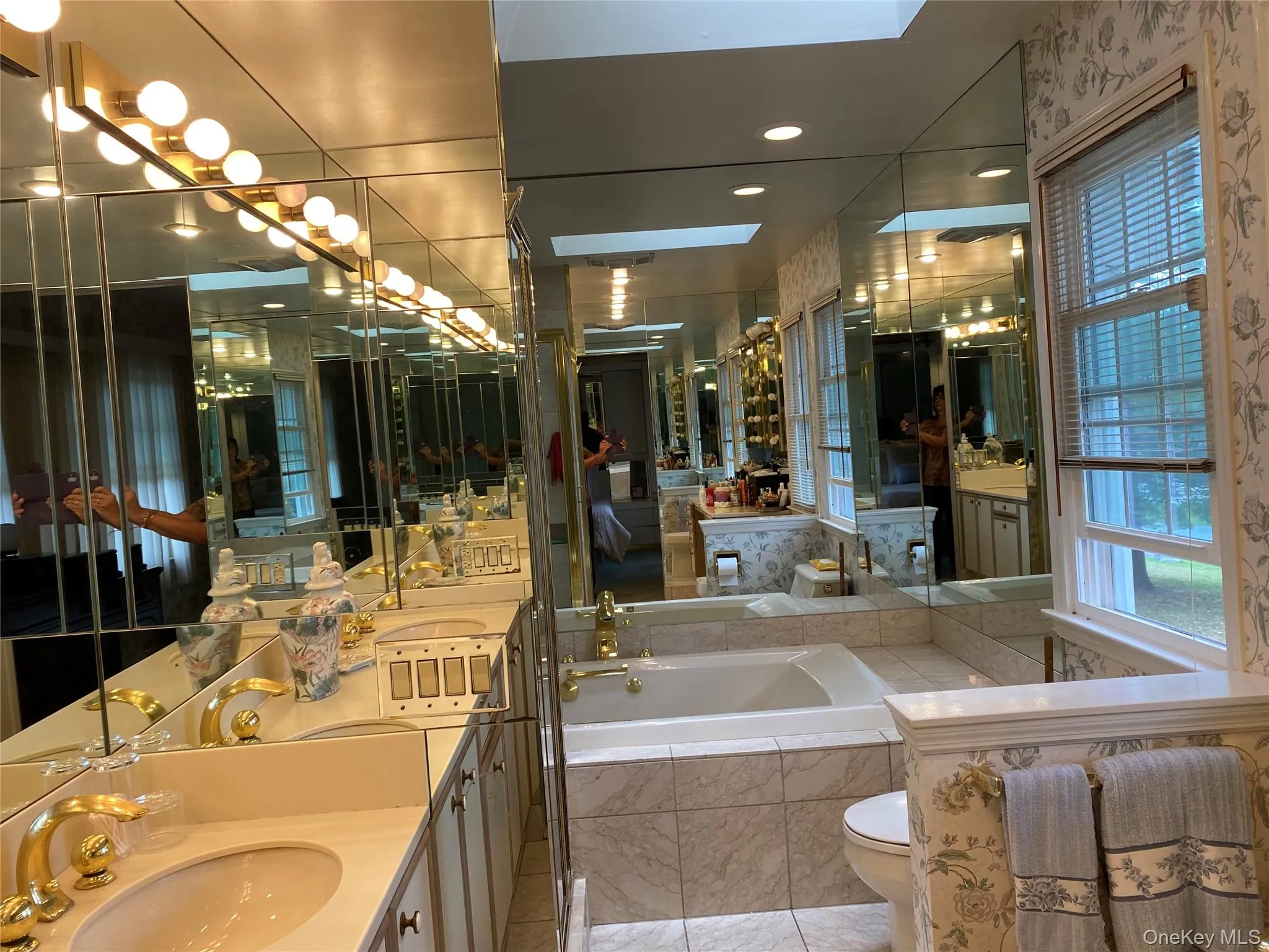 Master Bathroom featuring a skylight, vanity, tiled tub, tile patterned flooring, and toilet Master Bathroom featuring a skylight, vanity, tiled tub, tile patterned flooring, and toilet