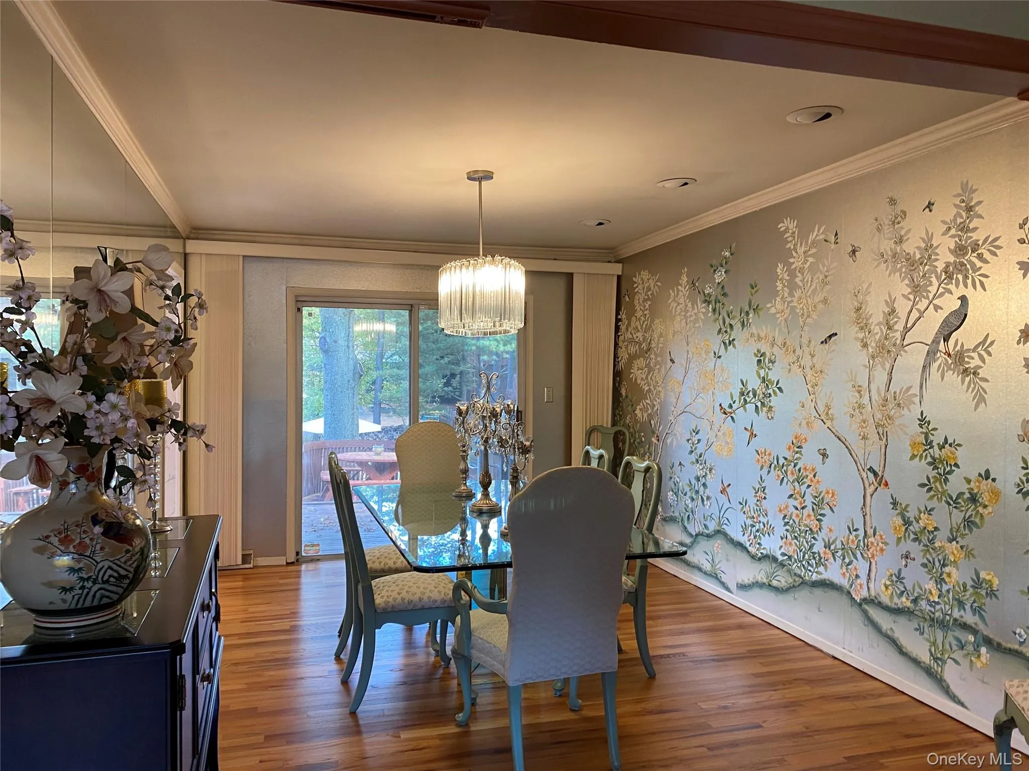 Dining space featuring a chandelier, wood-type flooring, and crown molding Dining space featuring a chandelier, wood-type flooring, and crown molding