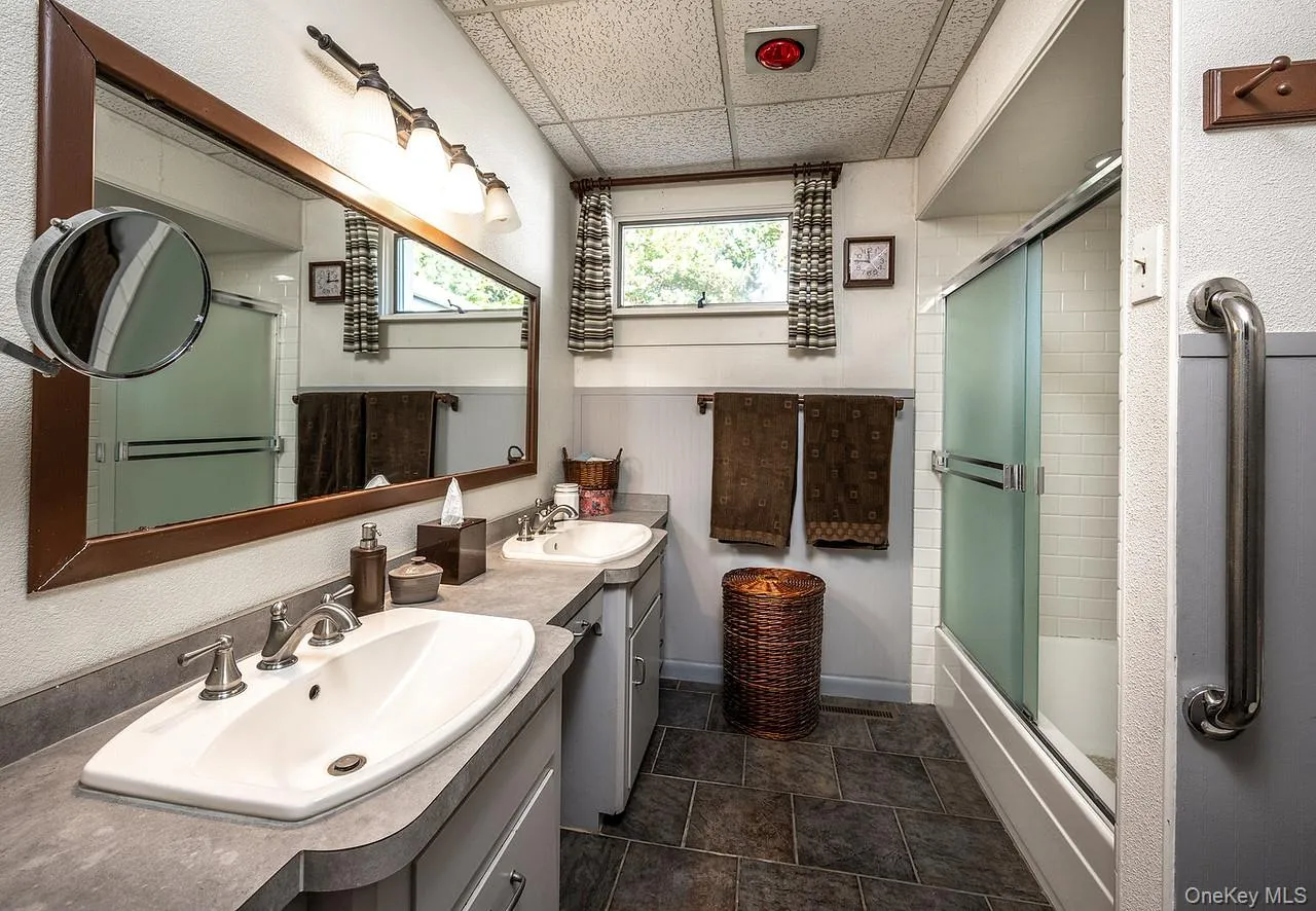 with glass door, and two vanities with glass door, and two vanities