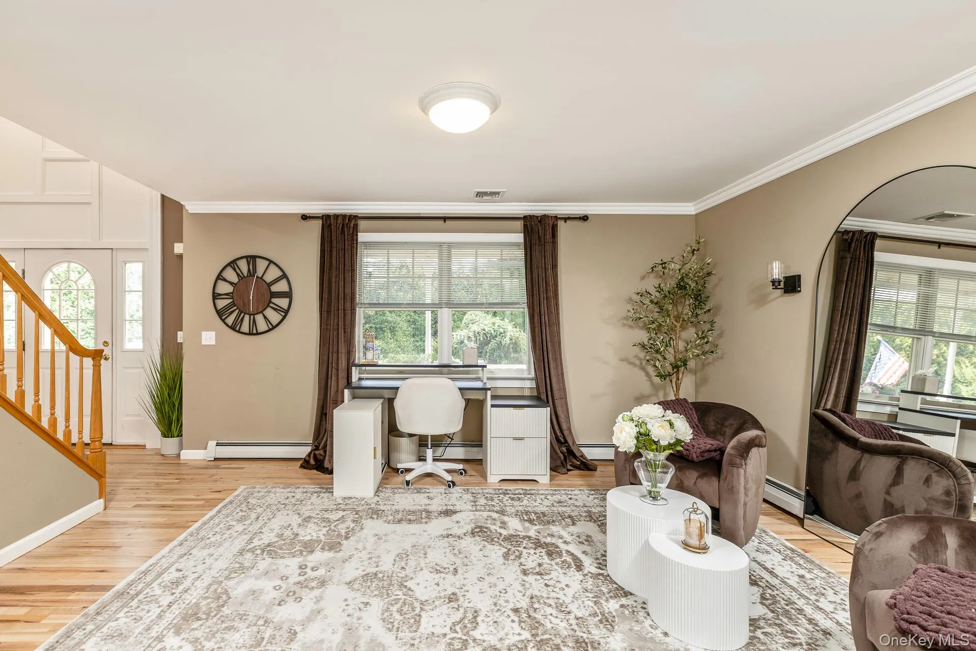 Entryway with wood-finish flooring, a white door with arched glass, and a natural wood staircase Entryway with wood-finish flooring, a white door with arched glass, and a natural wood staircase