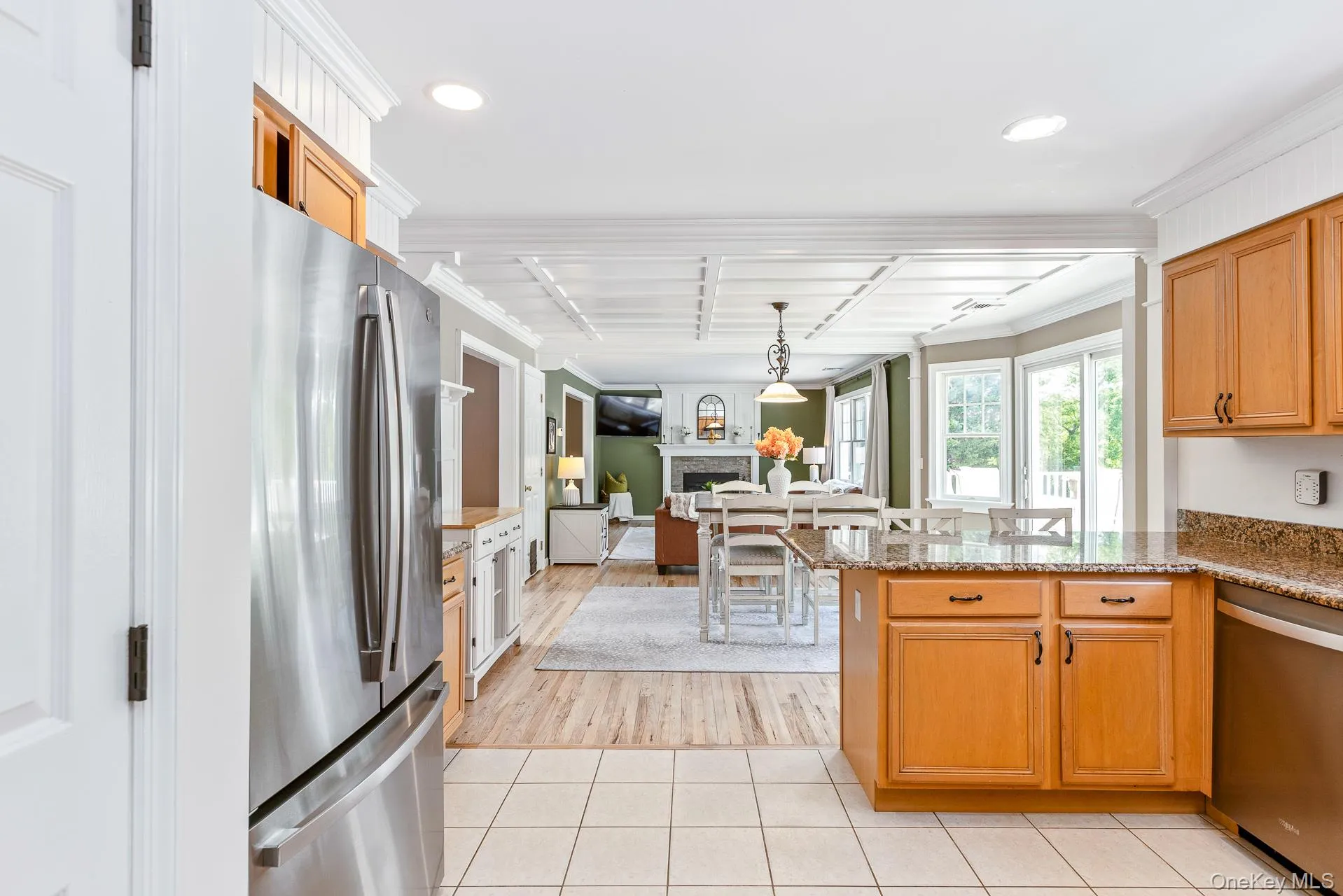 Kitchen with tile flooring and a granite-topped island, stainless steel appliances, and wood cabinetry Kitchen with tile flooring and a granite-topped island, stainless steel appliances, and wood cabinetry