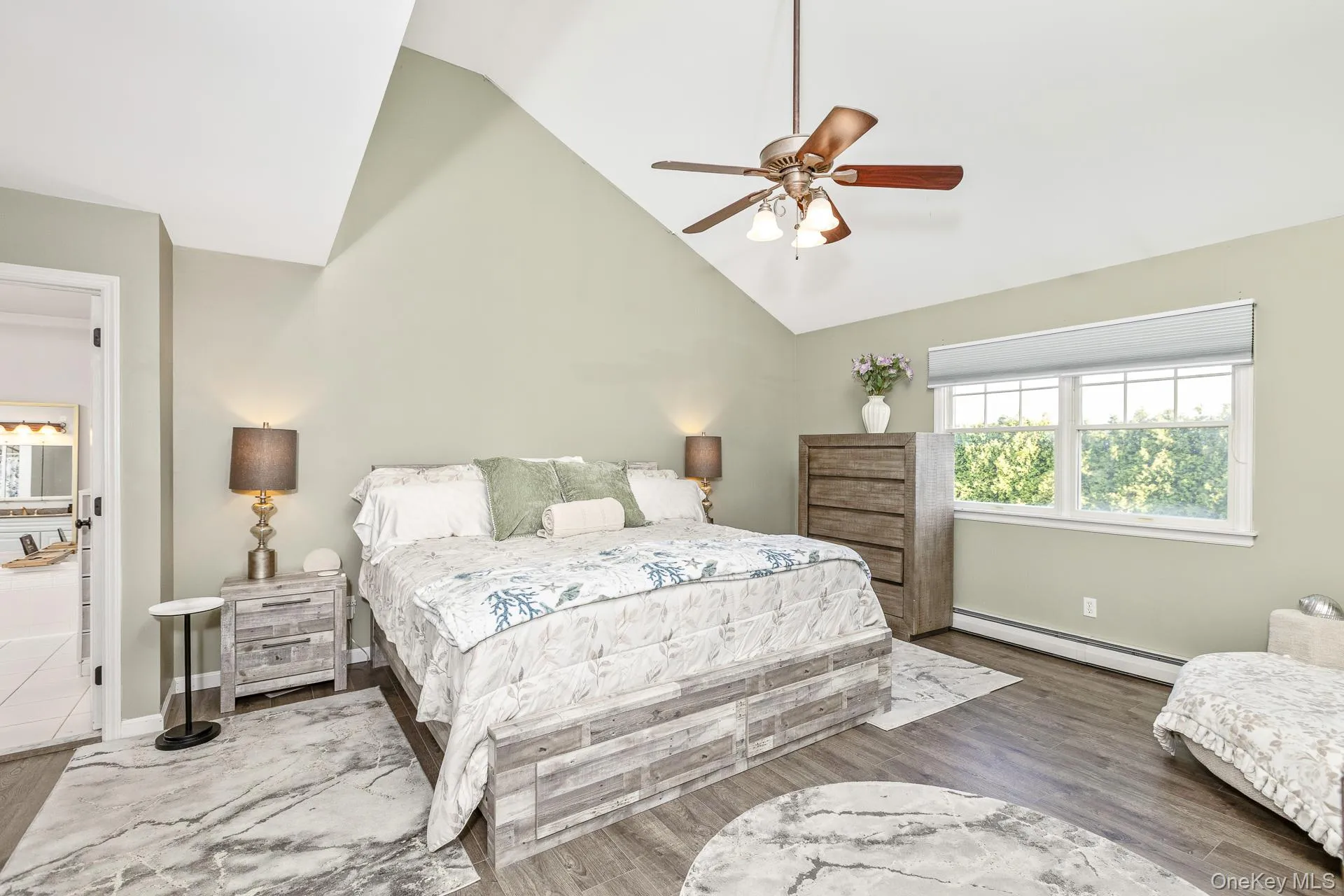 Vaulted ceiling with a ceiling fan, wood-finish flooring, and natural light from a window with a shade Vaulted ceiling with a ceiling fan, wood-finish flooring, and natural light from a window with a shade