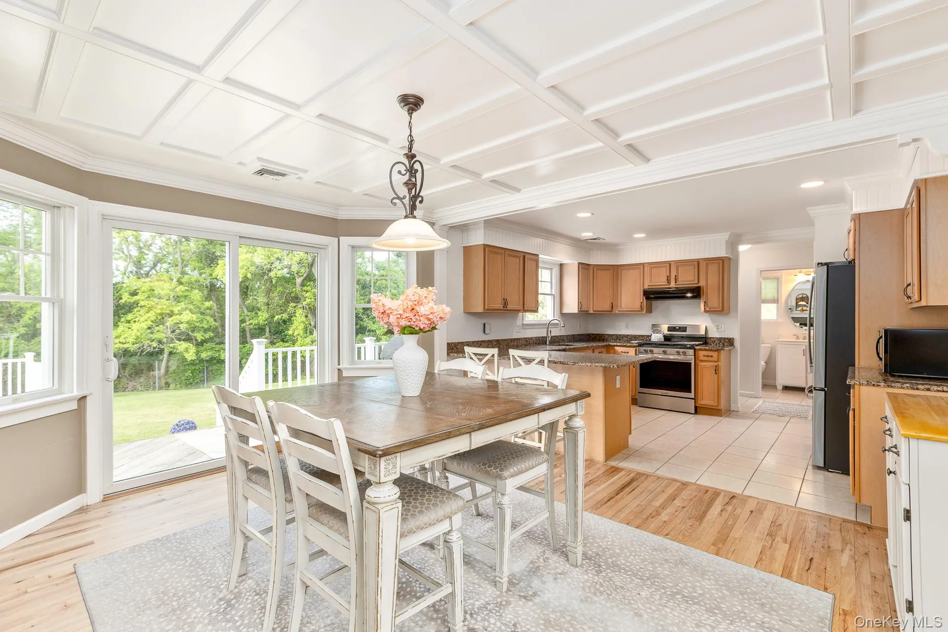 Coffered ceiling accenting a dining area with wood-finish flooring and a bay window Coffered ceiling accenting a dining area with wood-finish flooring and a bay window