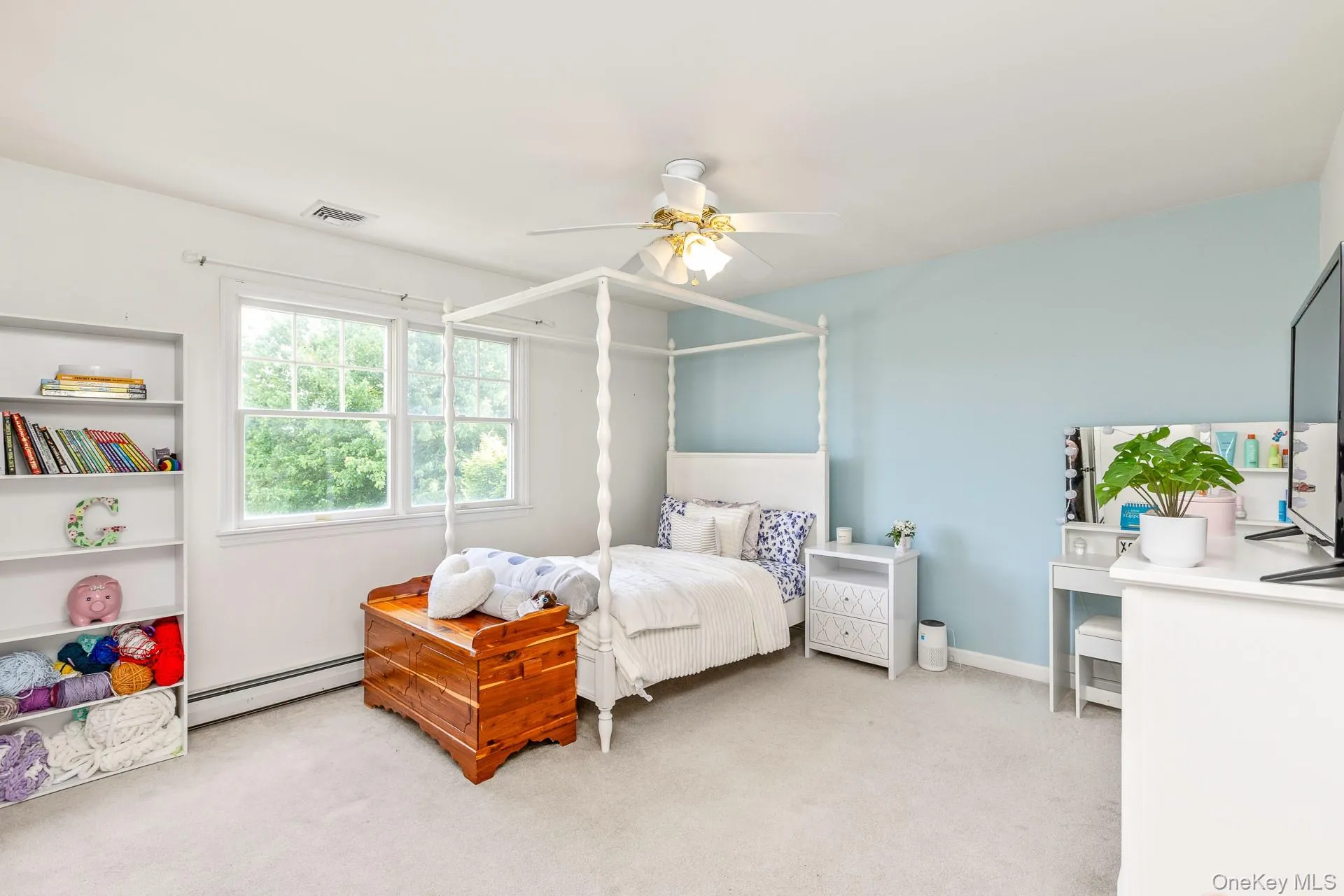 Carpeted room featuring a ceiling fan with integrated lighting, built-in shelving, and two large windows Carpeted room featuring a ceiling fan with integrated lighting, built-in shelving, and two large windows