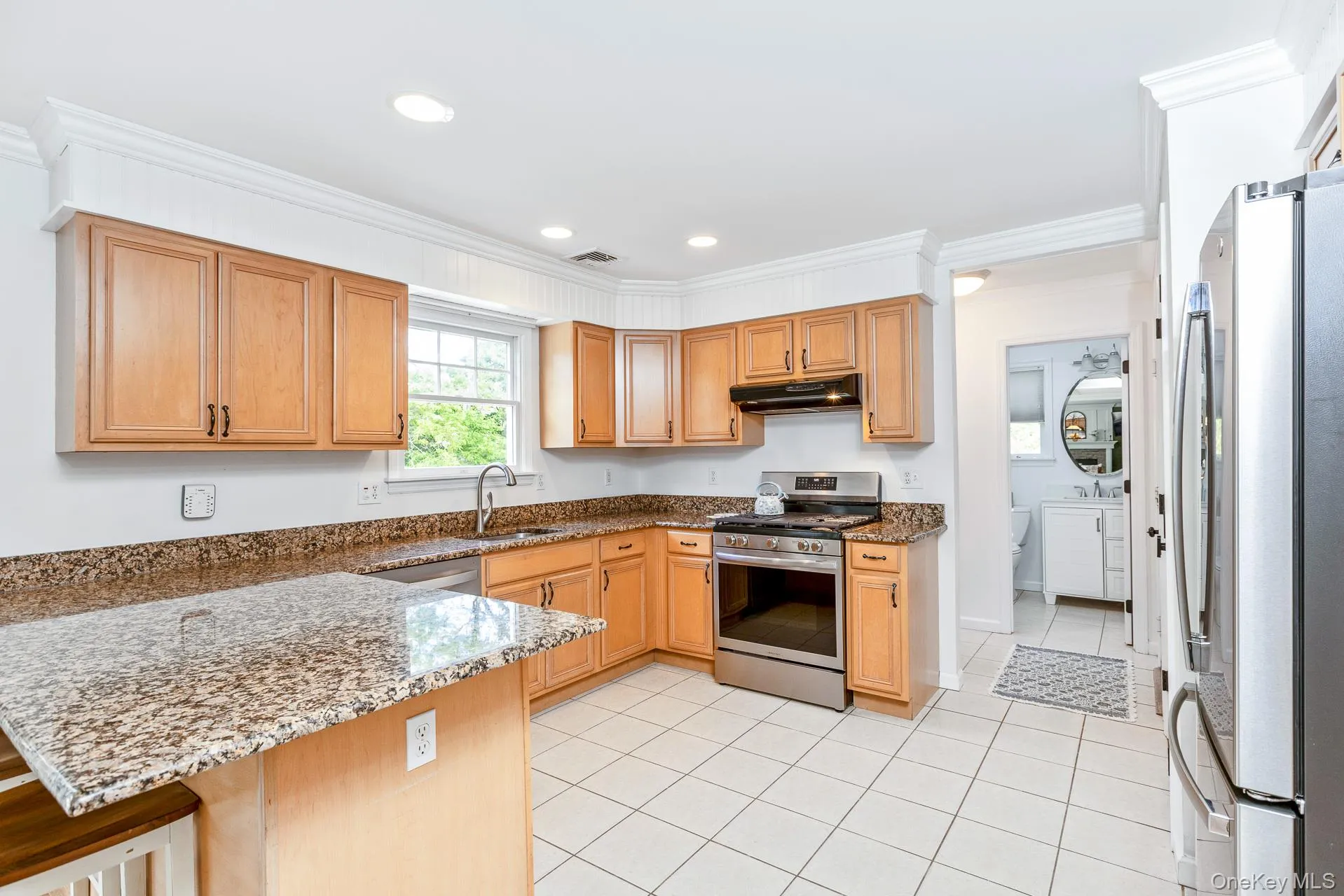 Kitchen featuring wood cabinetry, granite countertops, stainless steel appliances, tile flooring, and recessed lighting Kitchen featuring wood cabinetry, granite countertops, stainless steel appliances, tile flooring, and recessed lighting