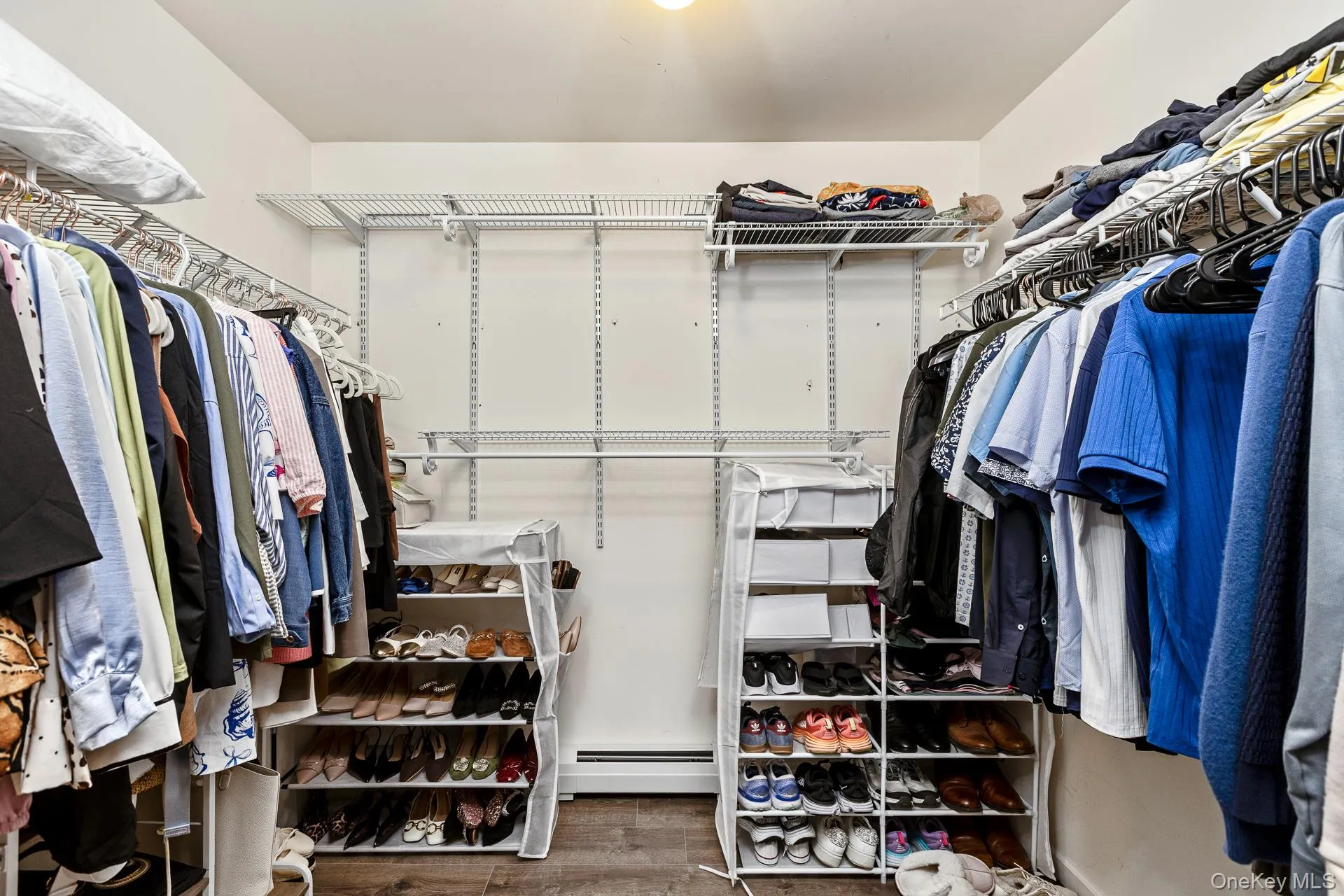 Walk-in closet featuring adjustable wire shelving and hanging rods Walk-in closet featuring adjustable wire shelving and hanging rods
