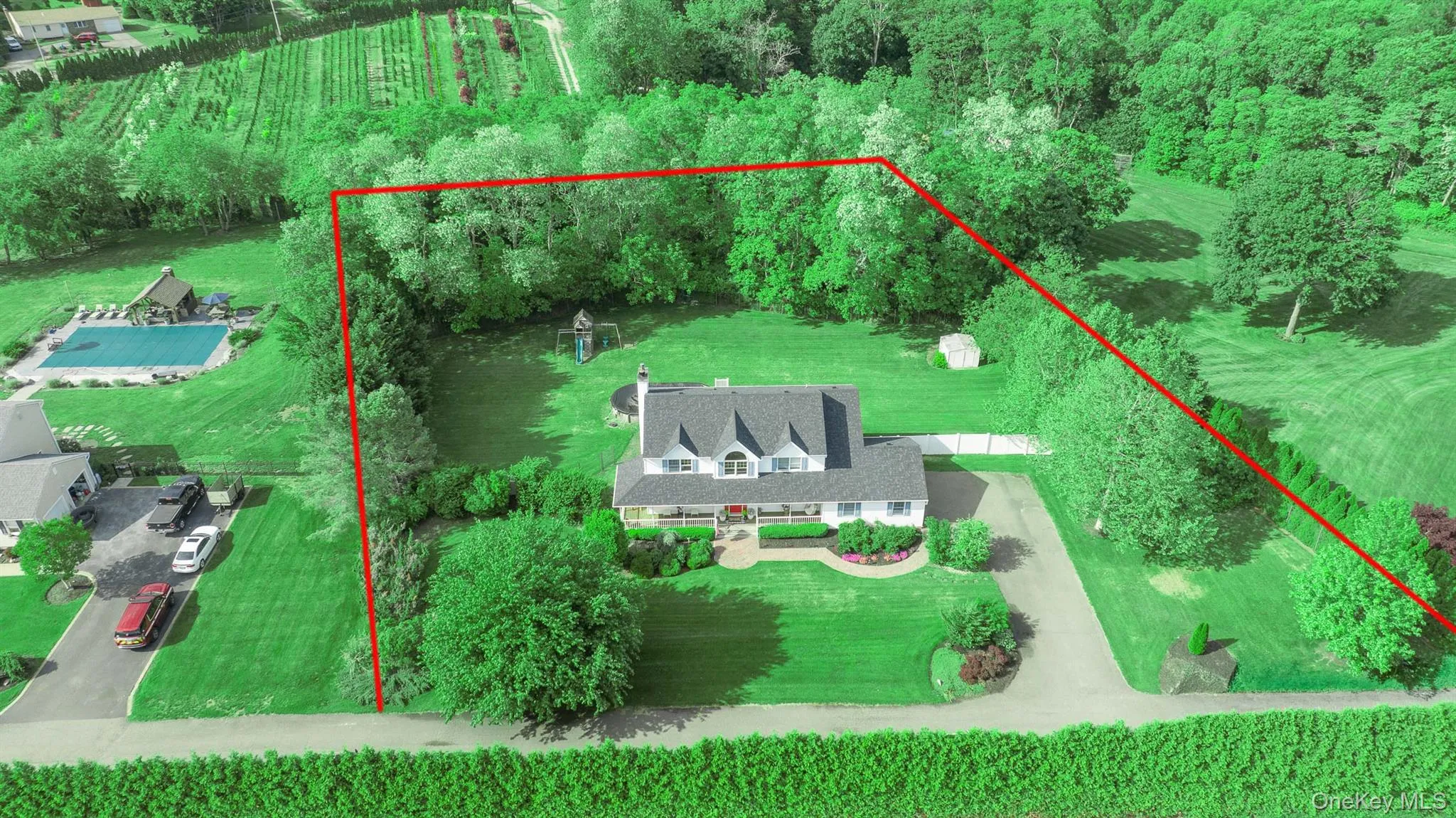 Expansive property featuring Colonial style residence with multiple gables and a covered front porch Expansive property featuring Colonial style residence with multiple gables and a covered front porch