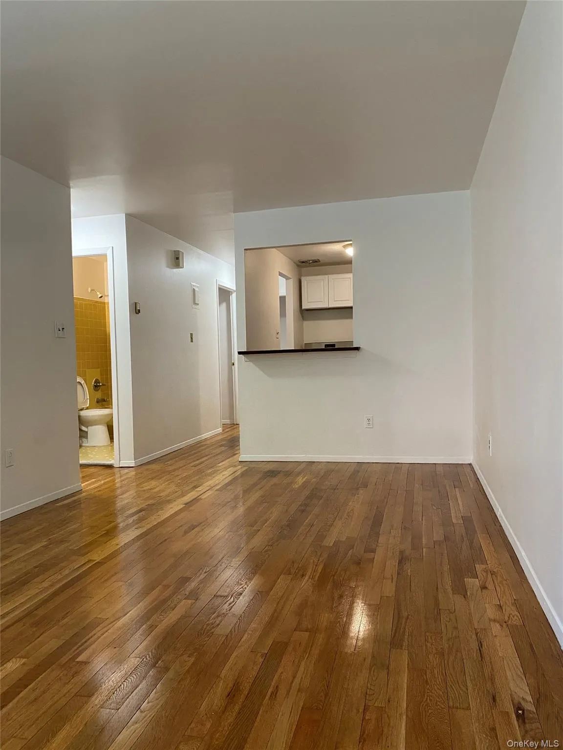 Unfurnished living room featuring dark wood finished floors and baseboards Unfurnished living room featuring dark wood finished floors and baseboards