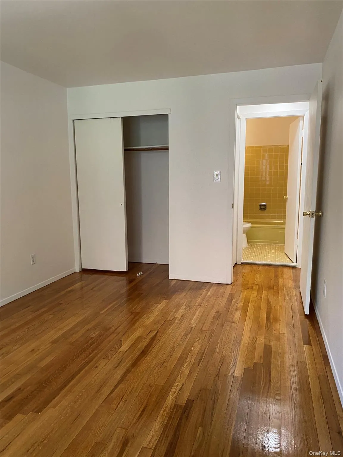 Unfurnished bedroom featuring hardwood / wood-style floors and a closet Unfurnished bedroom featuring hardwood / wood-style floors and a closet