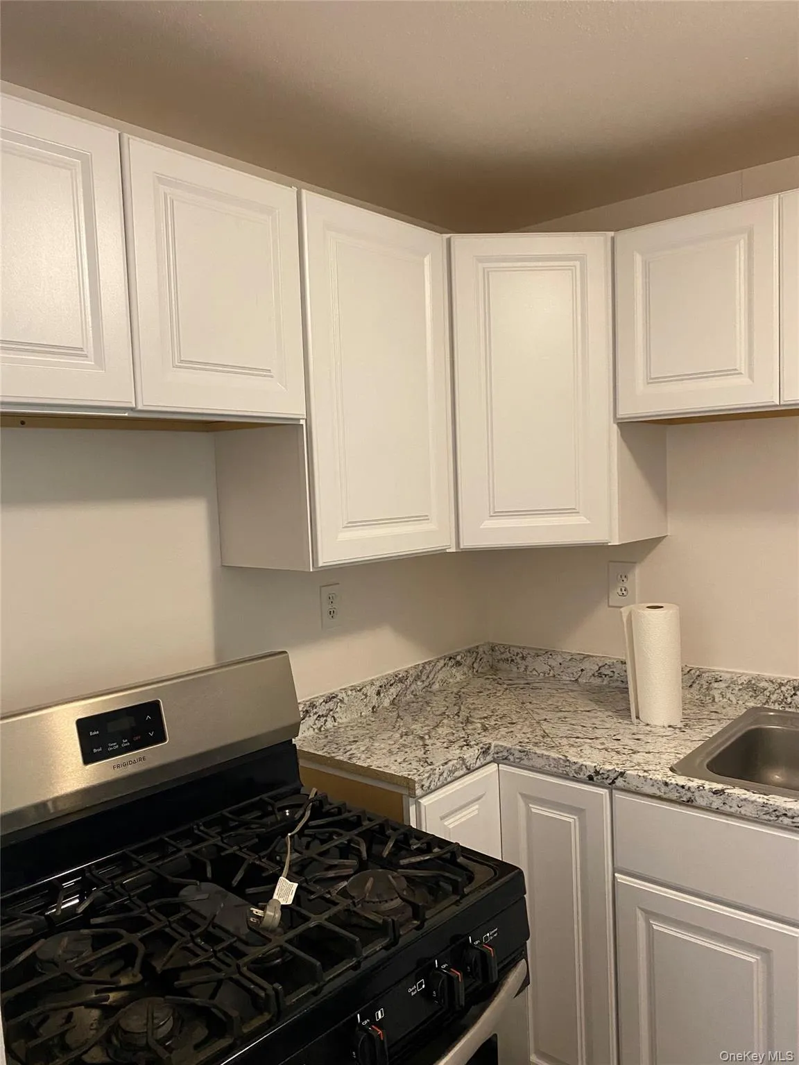Kitchen featuring white cabinetry, stainless steel gas range oven, and light countertops Kitchen featuring white cabinetry, stainless steel gas range oven, and light countertops