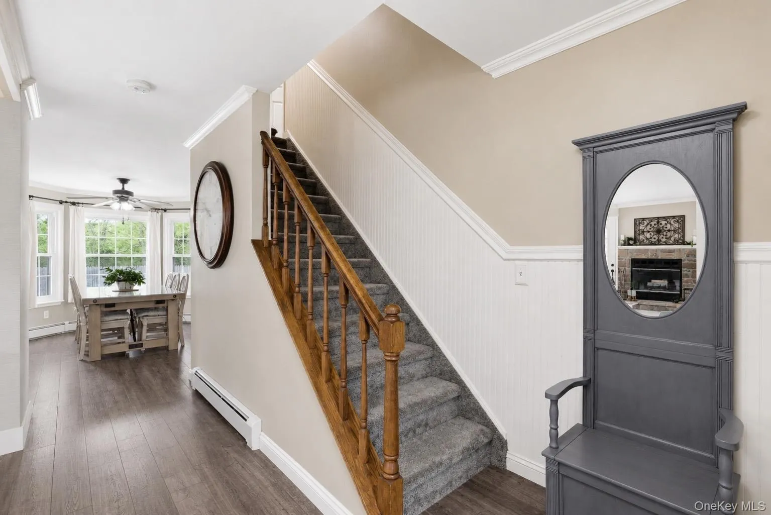 Entryway featuring Laminate flooring and a carpeted staircase with wood banister Entryway featuring Laminate flooring and a carpeted staircase with wood banister