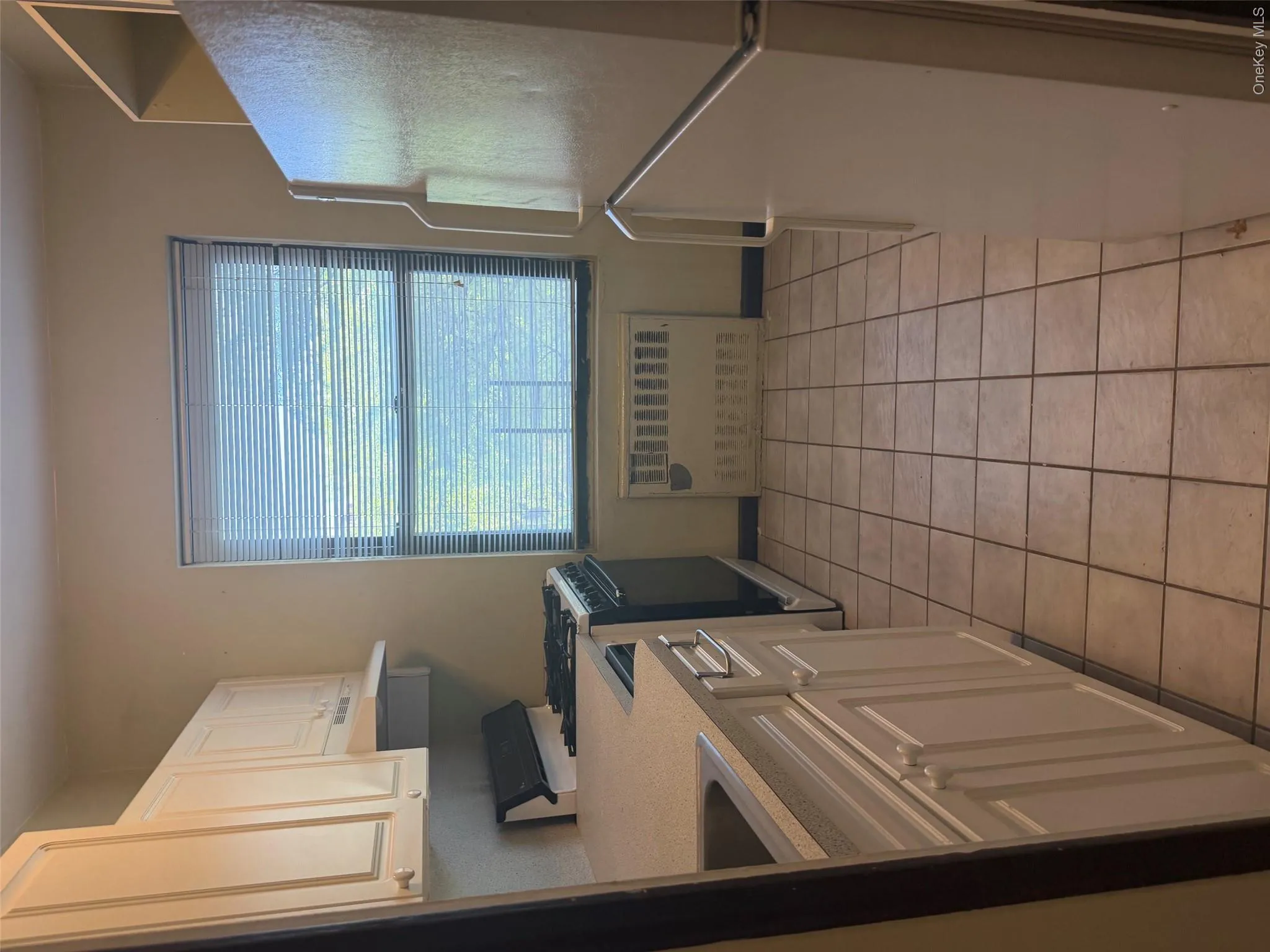 Kitchen featuring tile flooring, white cabinetry, a window with blinds, and white appliances Kitchen featuring tile flooring, white cabinetry, a window with blinds, and white appliances