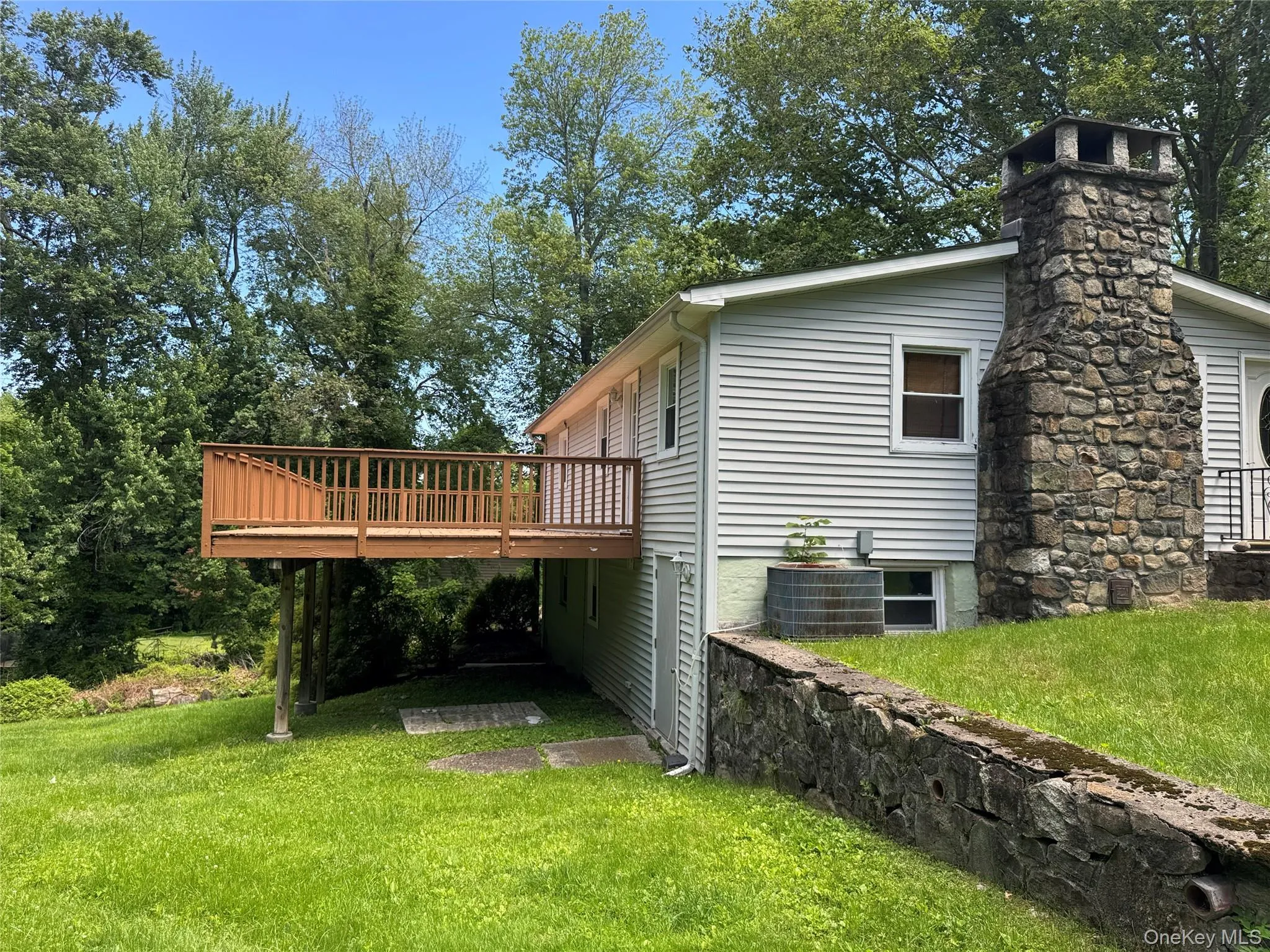 Back of house with view of deck Back of house with view of deck