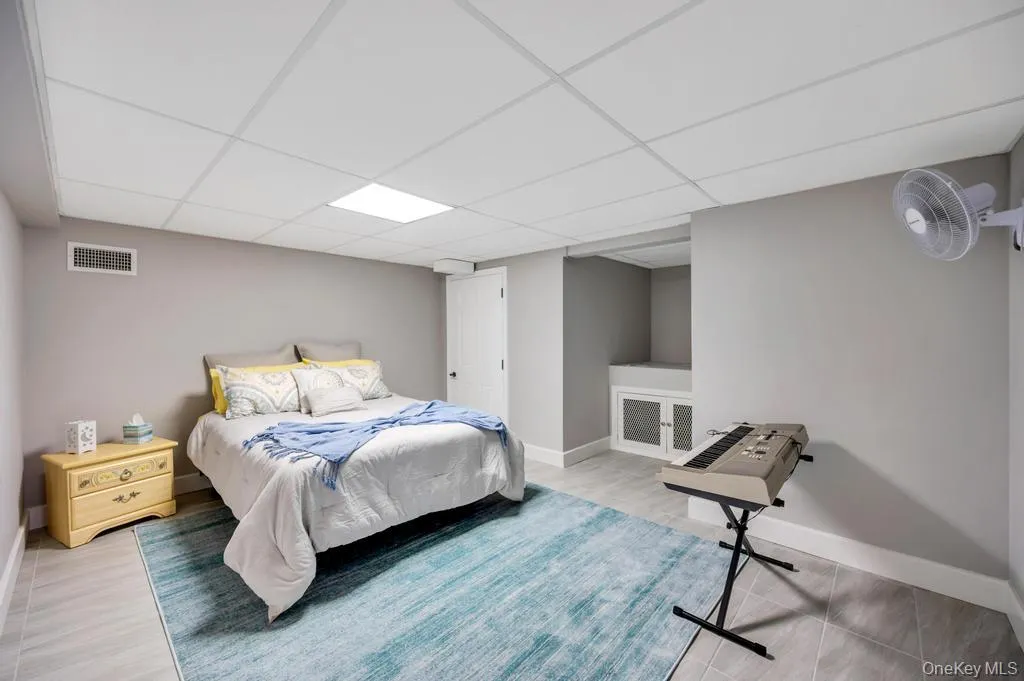 Neutral-toned room featuring a drop ceiling with recessed lighting Neutral-toned room featuring a drop ceiling with recessed lighting