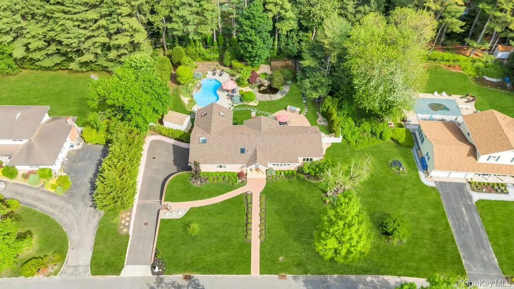 Expansive property featuring a central residence, a large freeform swimming pool, and extensive manicured landscaping Expansive property featuring a central residence, a large freeform swimming pool, and extensive manicured landscaping