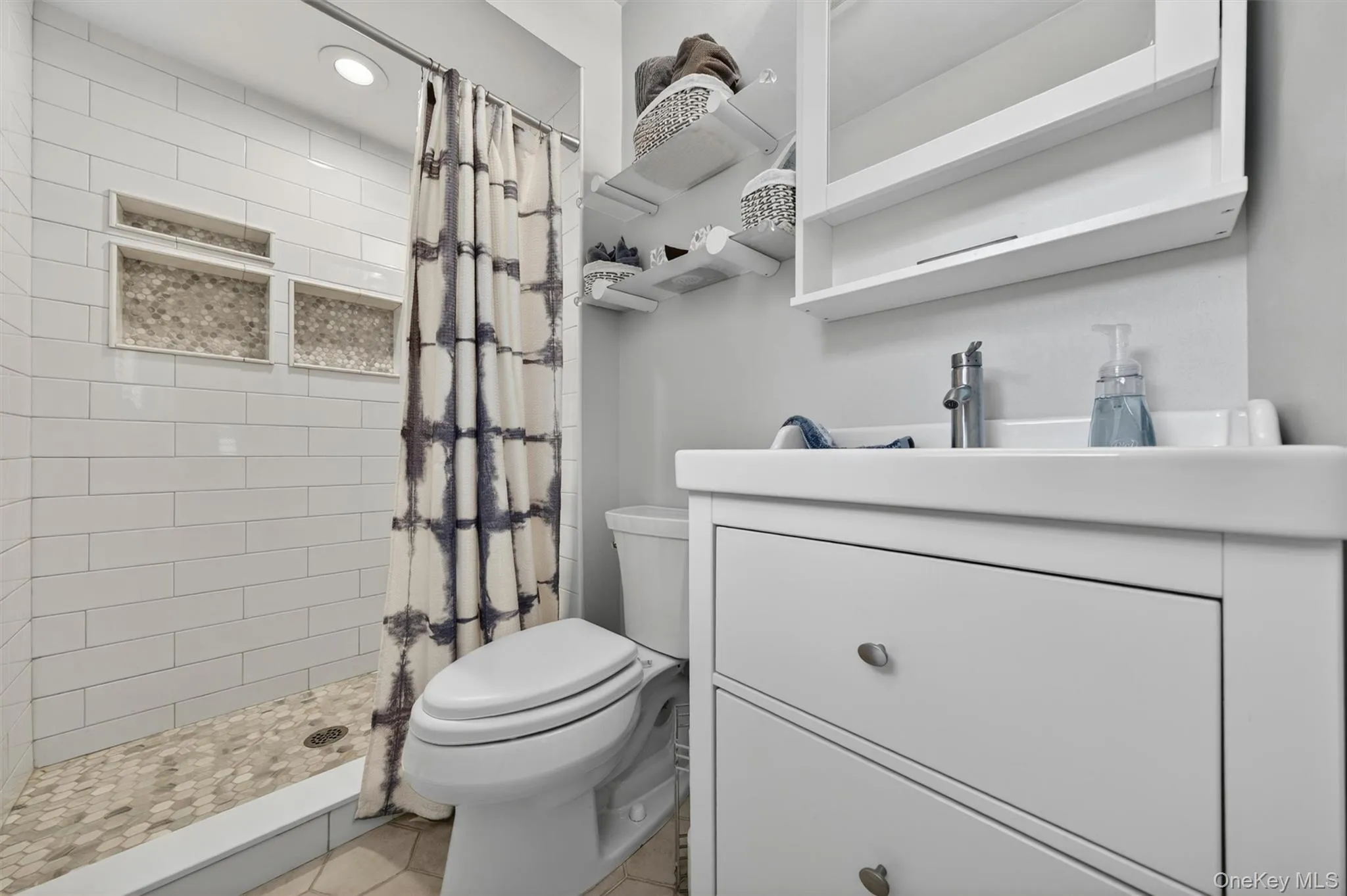 The primary bath offers a walk in tiled shower with built in niches. The primary bath offers a walk in tiled shower with built in niches.
