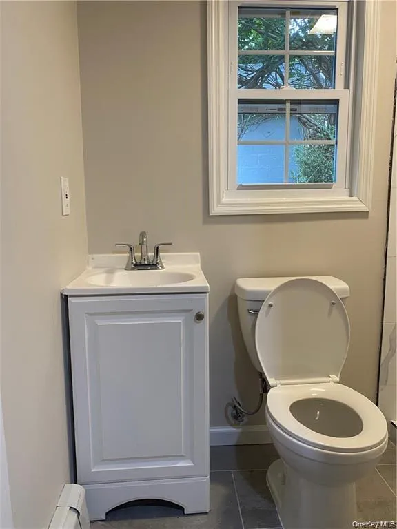 Another view of the bathroom with a window. Another view of the bathroom with a window.